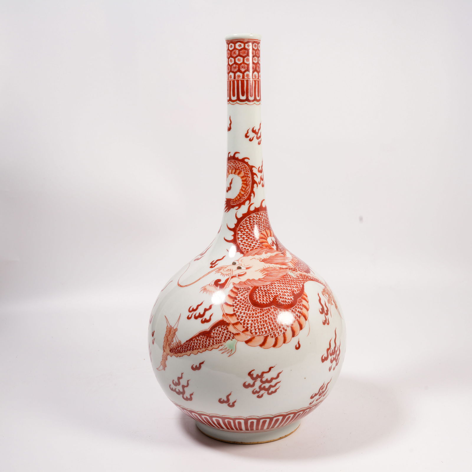 A UNDERGLAZE-RED LONG-NECK VASE WITH CLOUD-AND-DRAGON DESIGN: Underglaze-Red Long-Neck Vase with Cloud-and-Dragon Design