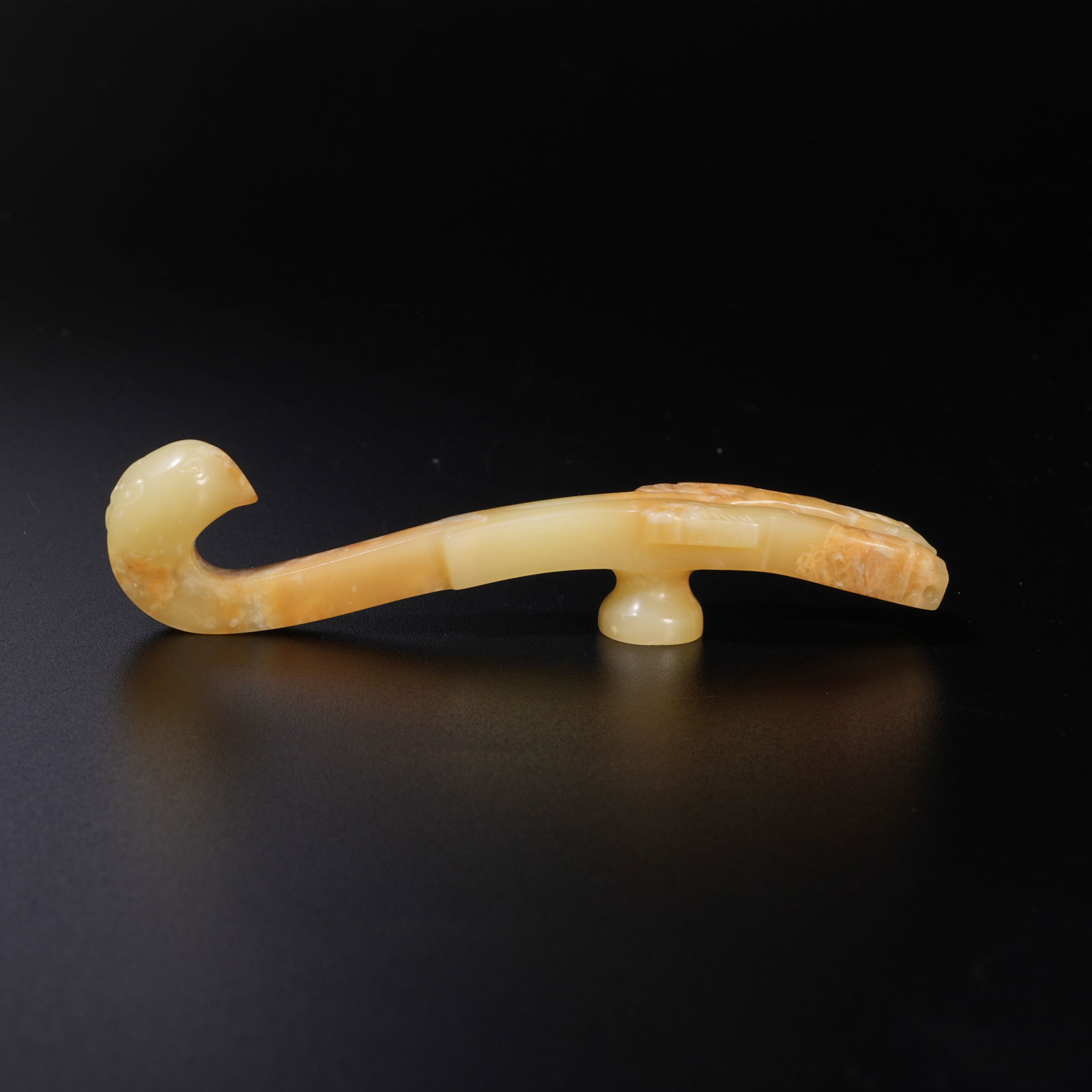 A HETIAN YELLOW JADE CARVED BIRD-SHAPED BELT HOOK: Hetian Yellow Jade Carved Bird-Shaped Belt Hook