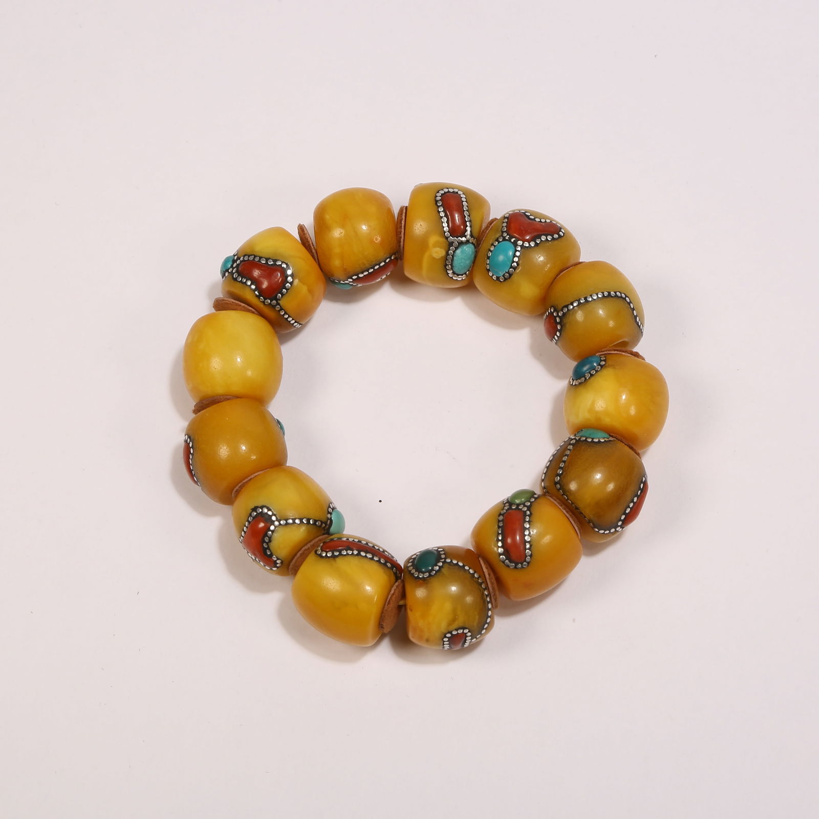 A AMBER BRACELET INLAID WITH GEMSTONES: Amber bracelet inlaid with gemstones