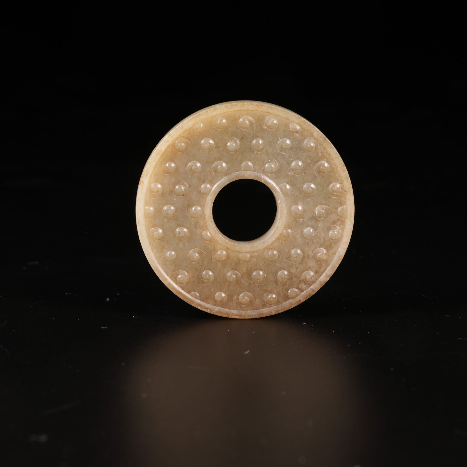 A ANCIENT JADE DISC WITH RAISED STUDS: Ancient Jade Disc with Raised Studs