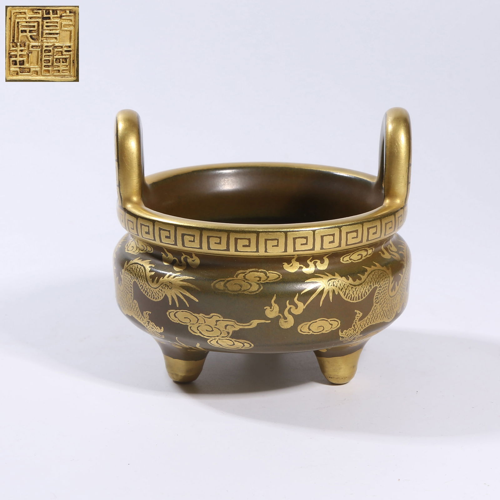 A TEA-DUST GLAZE GILDED CLOUD-AND-DRAGON CHASING-PEARL TRIPOD CENSER WITH HIGH HANDLES: Tea-dust glaze gilded cloud-and-dragon chasing-pearl tripod censer with high handles