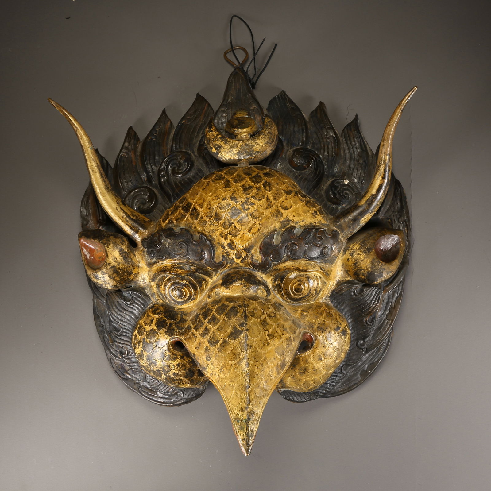 A PARTIALLY GILDED BRONZE HAMMERED GARUDA MASK: Partially gilded bronze hammered Garuda mask