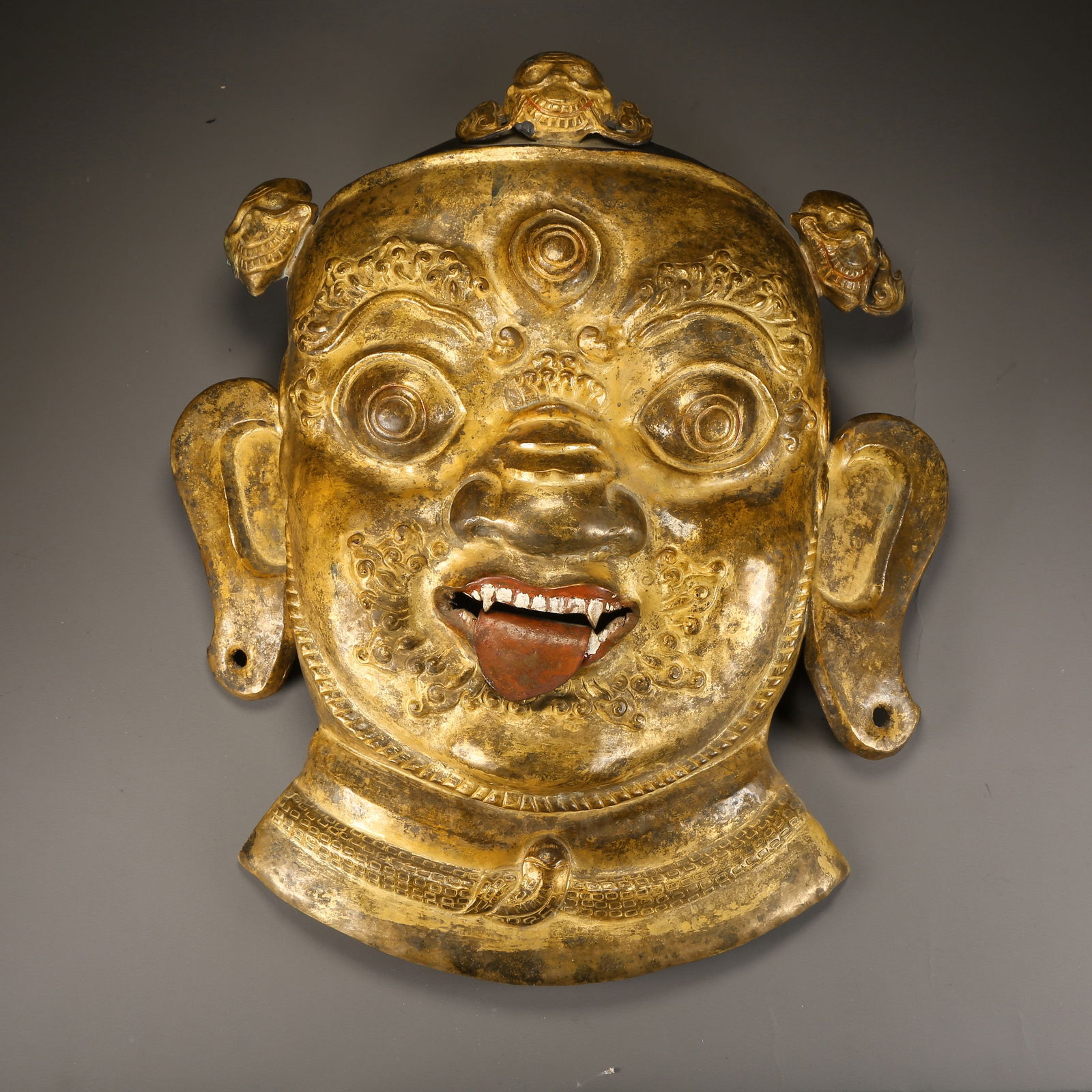 A GILDED BRONZE HAMMERED DHARMAPALA MASK (1 of 8)