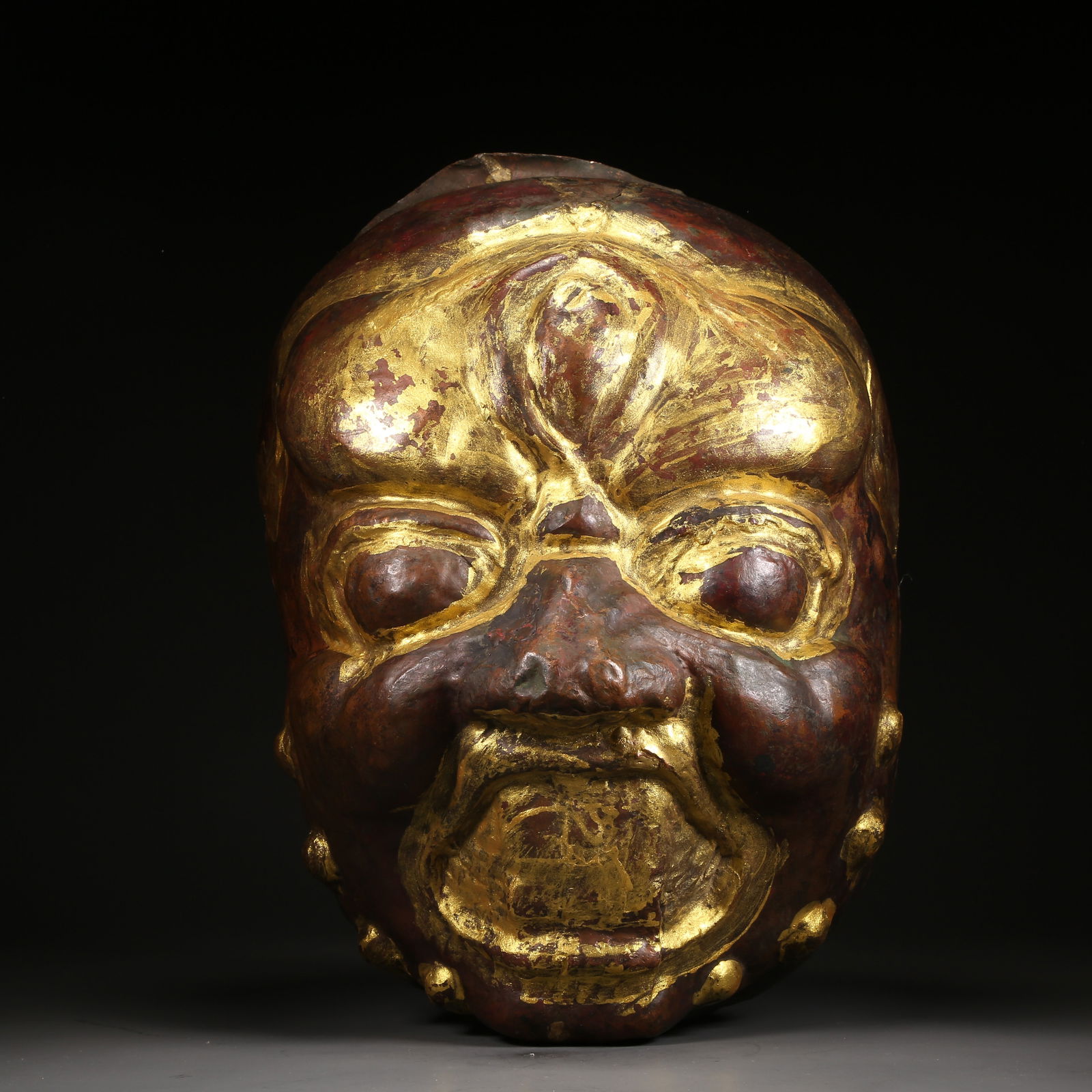 A BRONZE HAMMERED MASK (1 of 9)