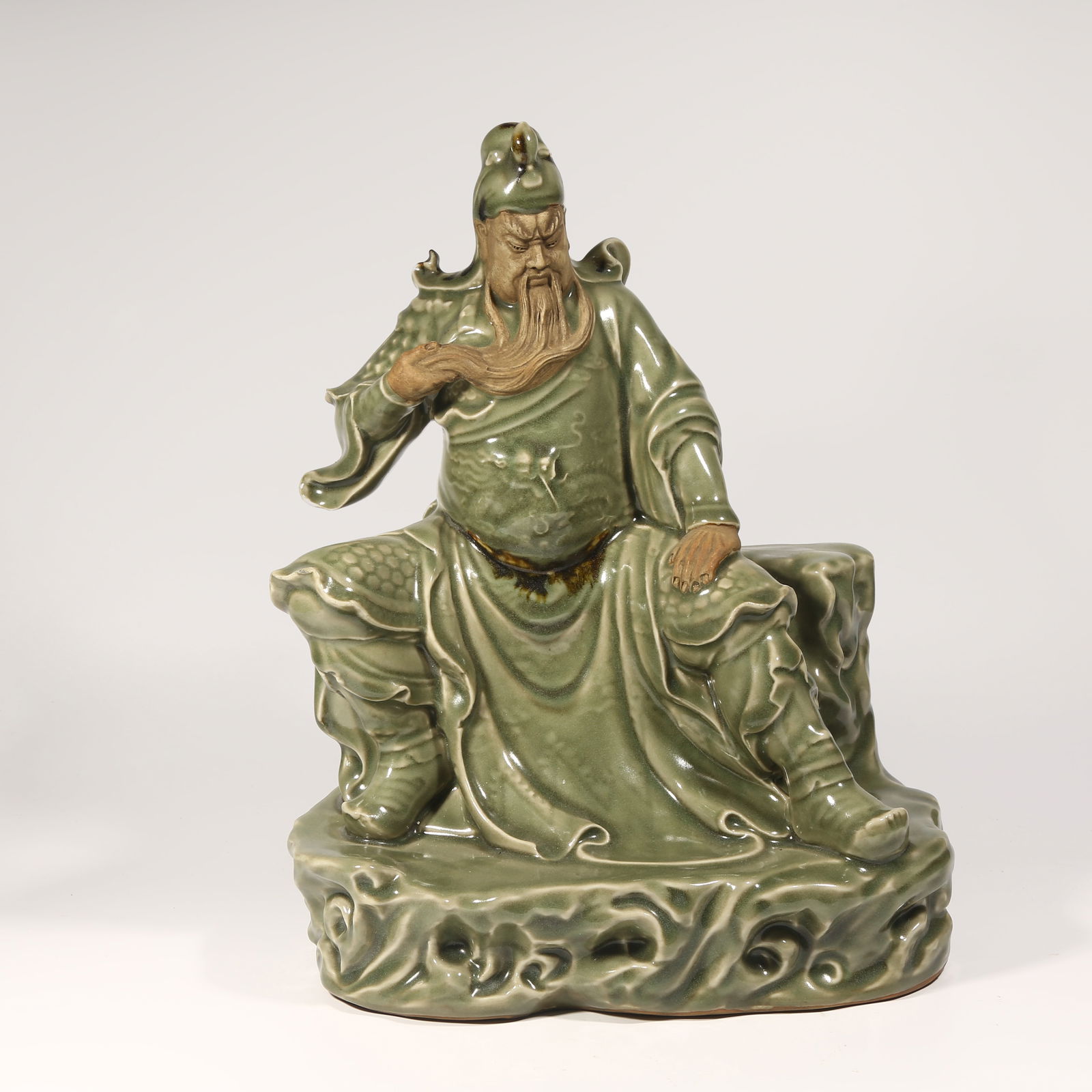 A LONGQUAN KILN SEATED STATUE OF GUAN YU: Longquan Kiln Seated Statue of Guan Yu