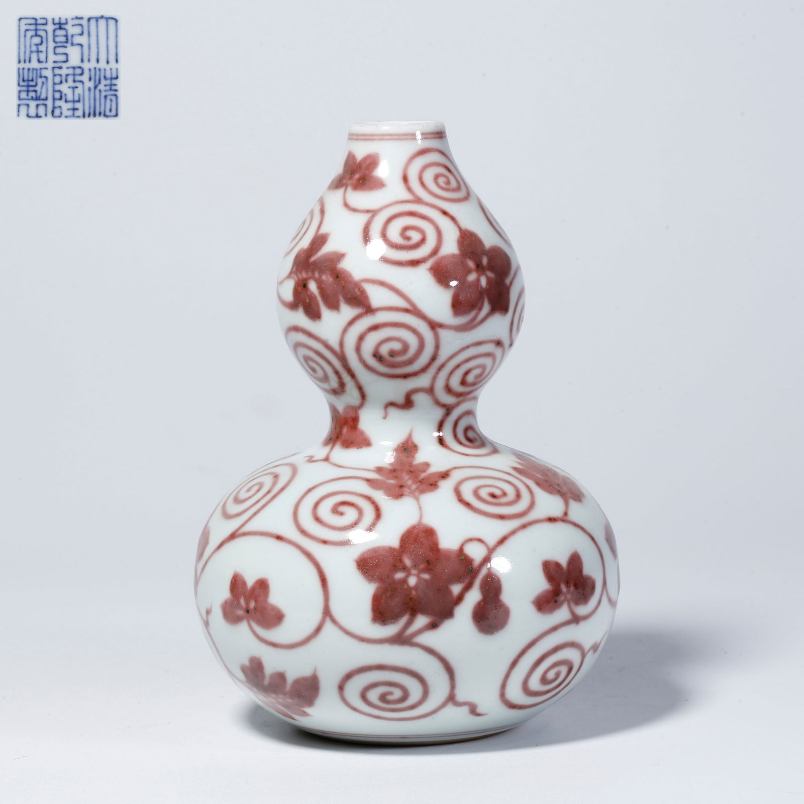A UNDERGLAZE RED GOURD VASE WITH GOURD MOTIF: Underglaze red gourd vase with gourd motif