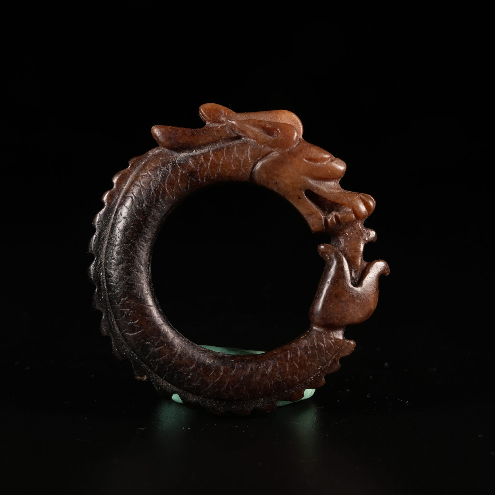 A OUROBOROS DRAGON ORNAMENT IN ARCHAIC JADE: Ouroboros Dragon Ornament in Archaic Jade