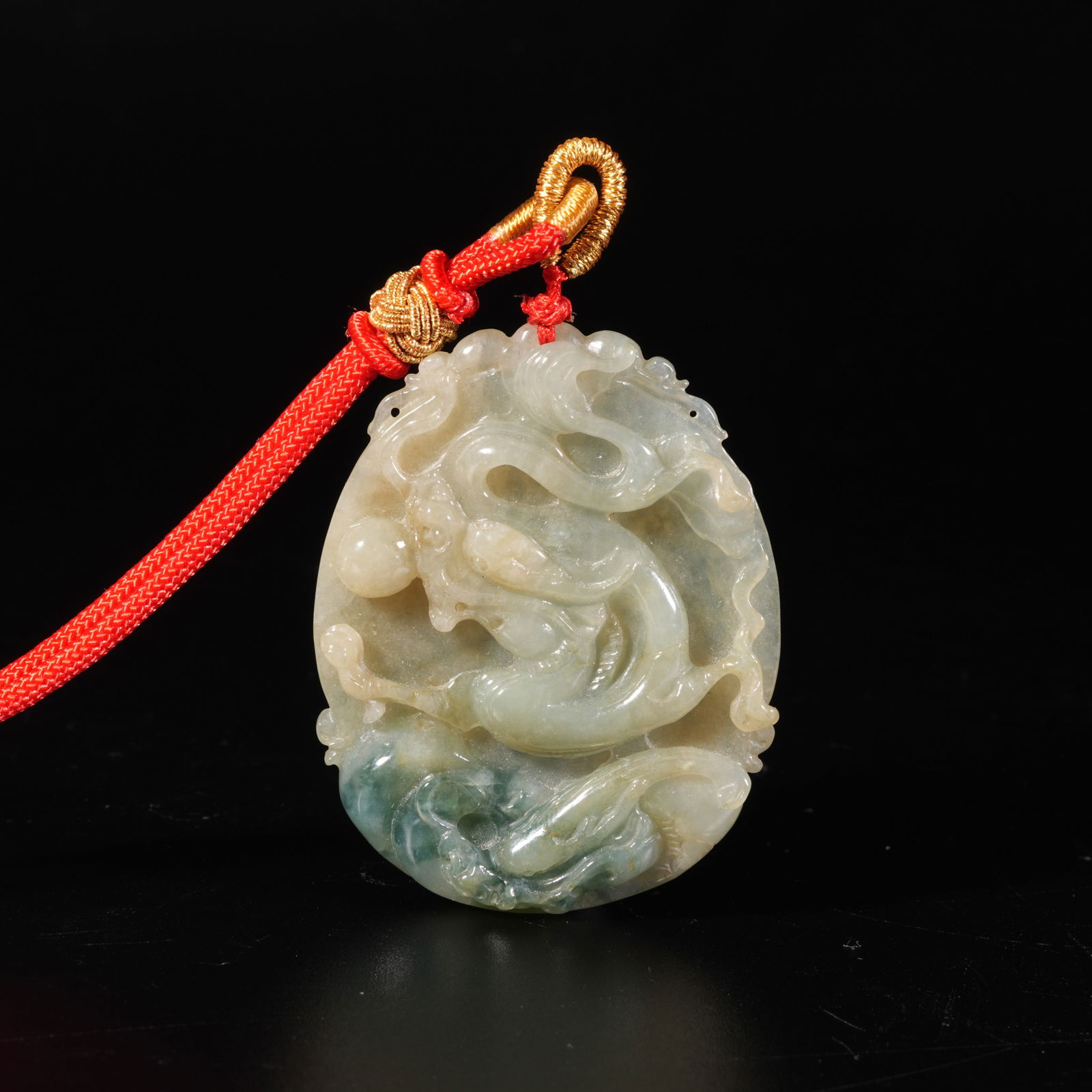 A JADEITE PENDANT WITH SEAWATER DRAGON PATTERN: Jadeite Pendant with Seawater Dragon Pattern
