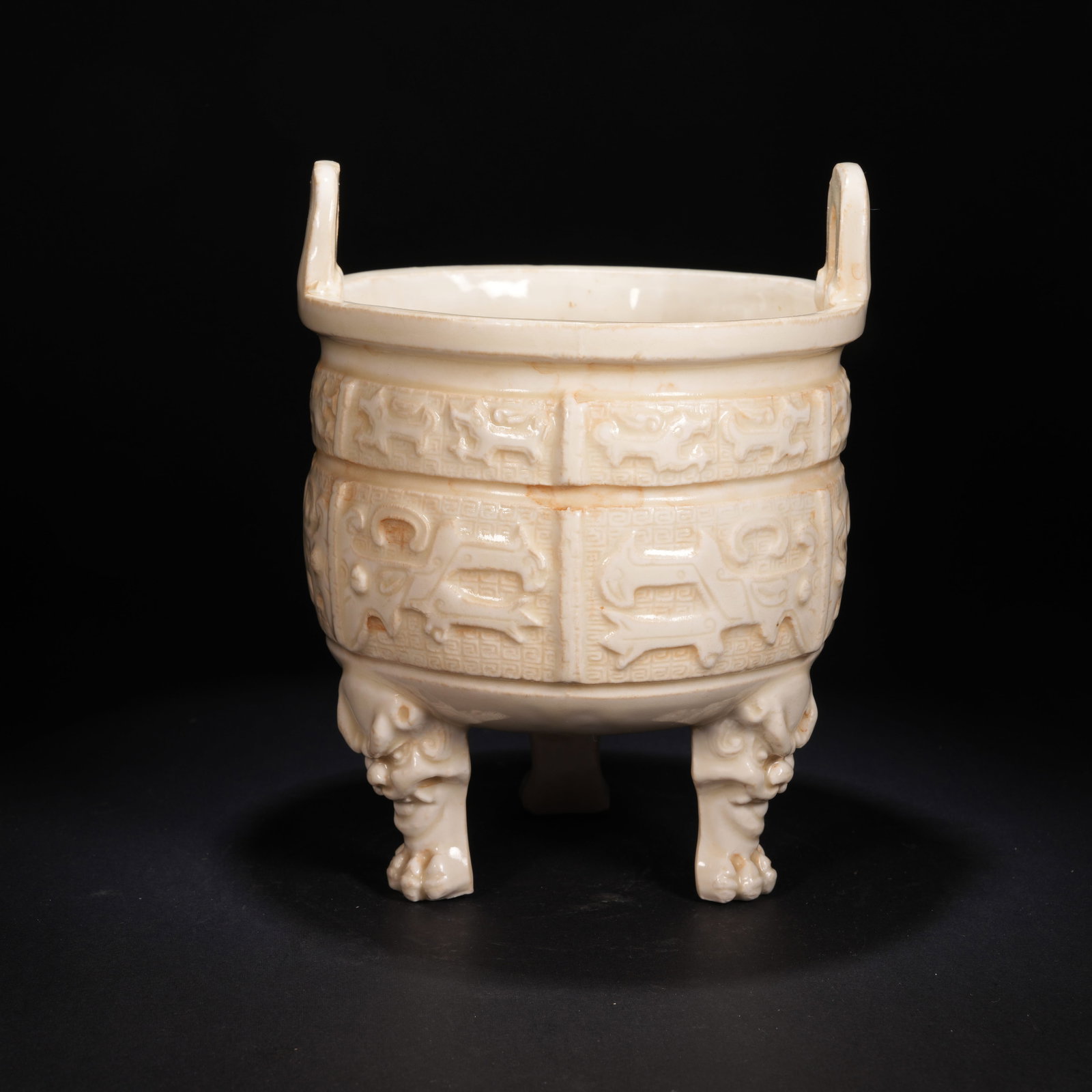 A DING KILN BEAST-FACE MOTIF CENSER WITH THREE BEAST FEET AND UPRIGHT HANDLES: Ding Kiln Beast-Face Motif Censer with Three Beast Feet and Upright Handles