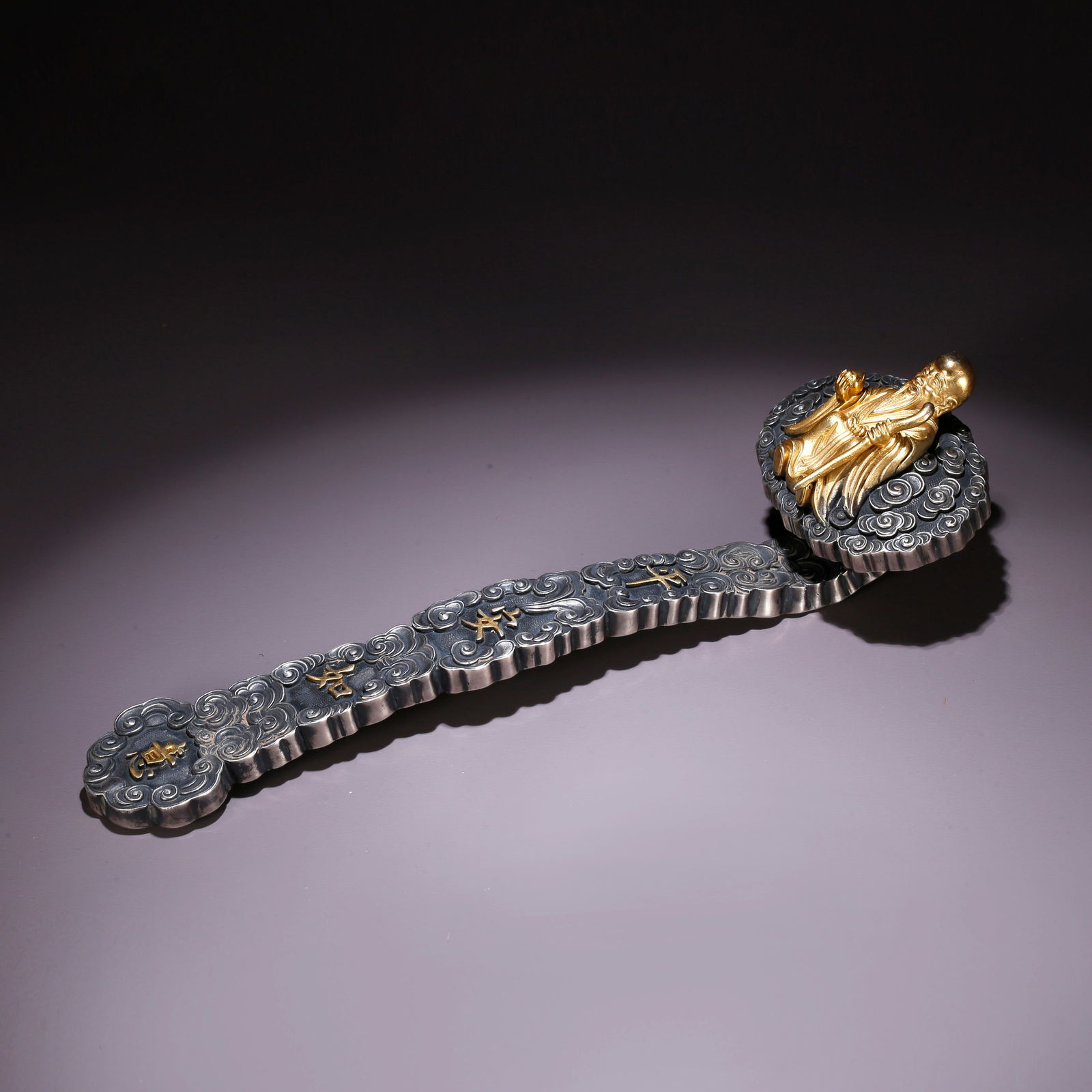 A SILVER RUYI WITH SHOU STAR PATTERN: Silver Ruyi with Shou Star Pattern