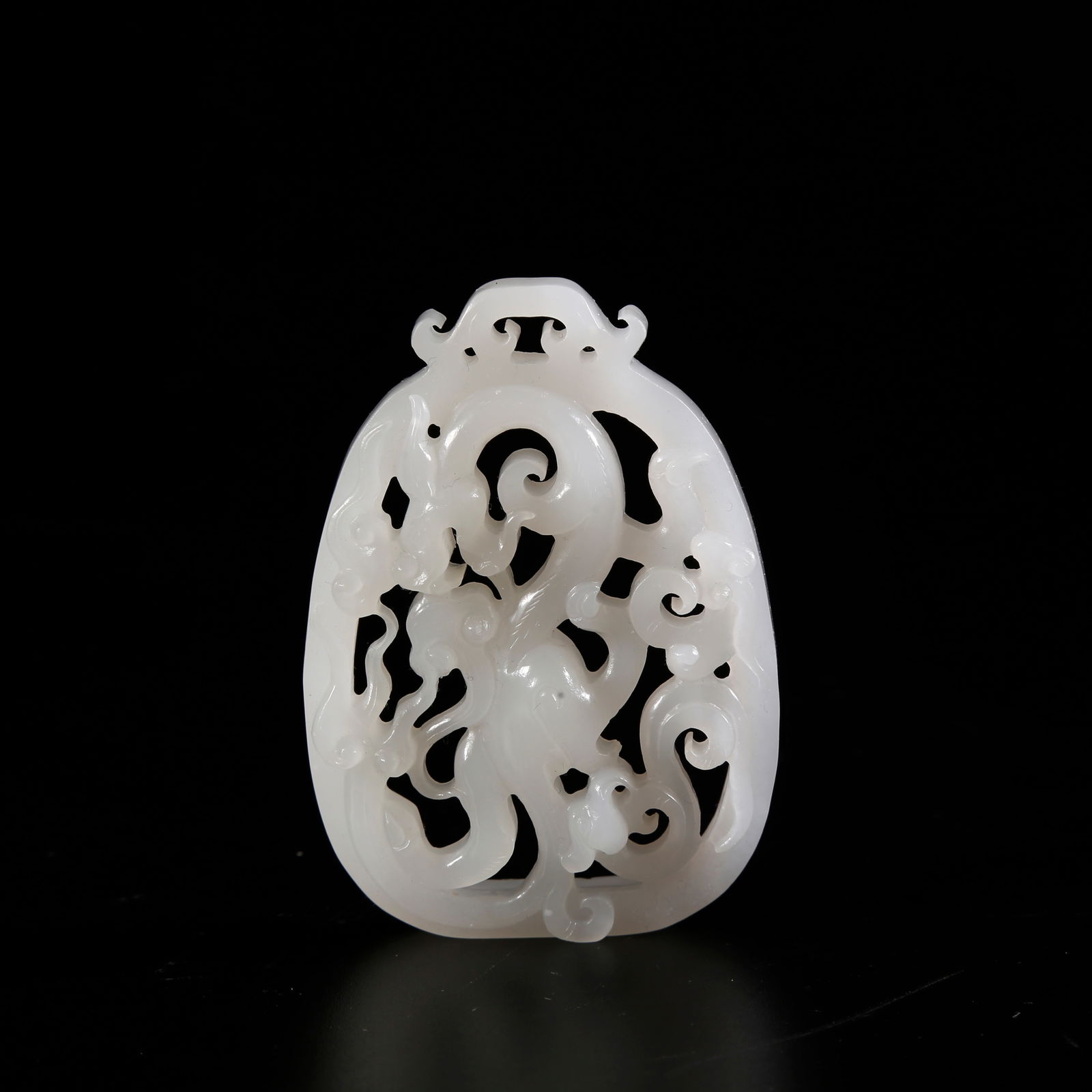 A HETIAN JADE PENDANT WITH DRAGON MOTIF: Hetian jade pendant with dragon motif