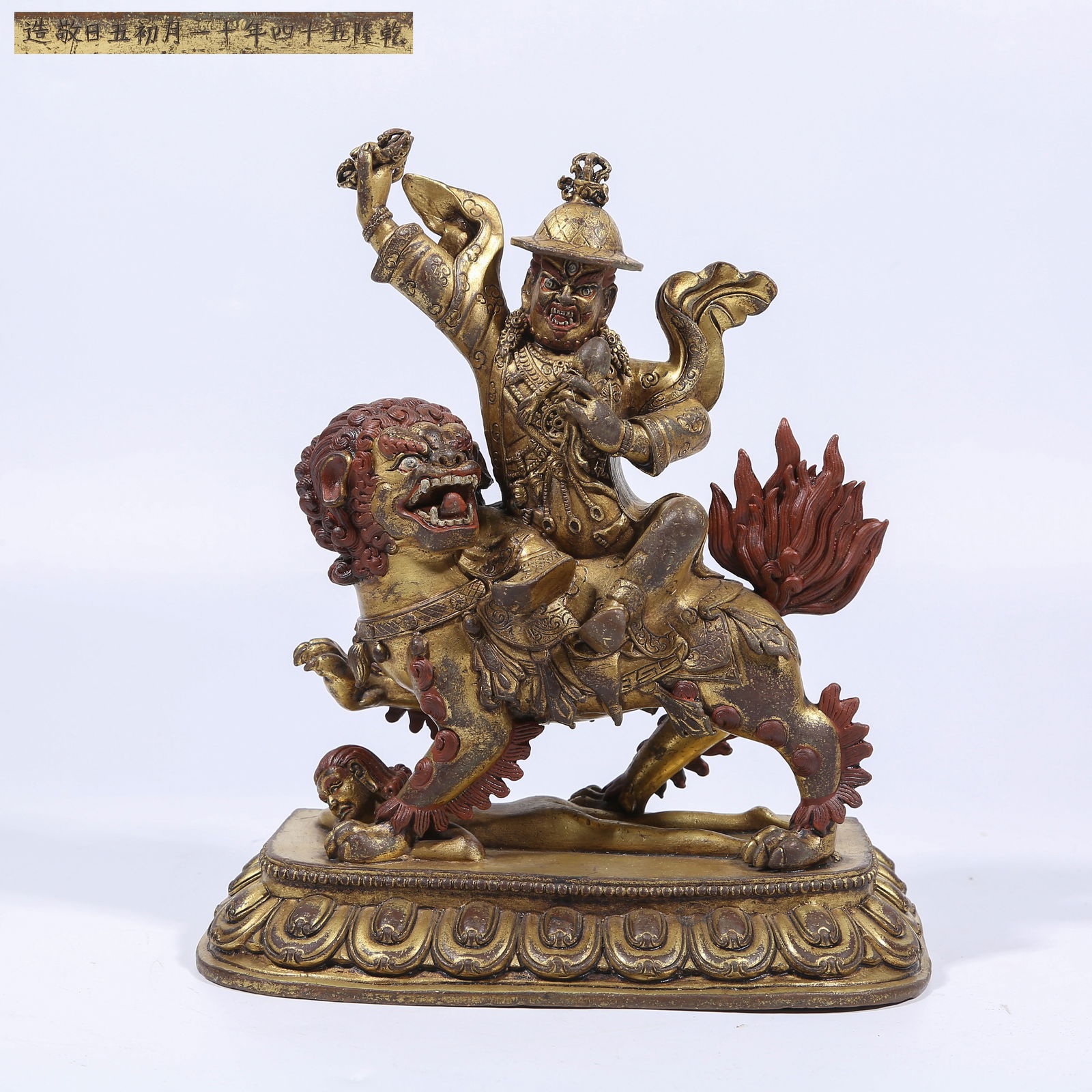 A GILT BRONZE LION-RIDING DHARMA PROTECTOR STATUE: Gilt Bronze Lion-Riding Dharma Protector Statue