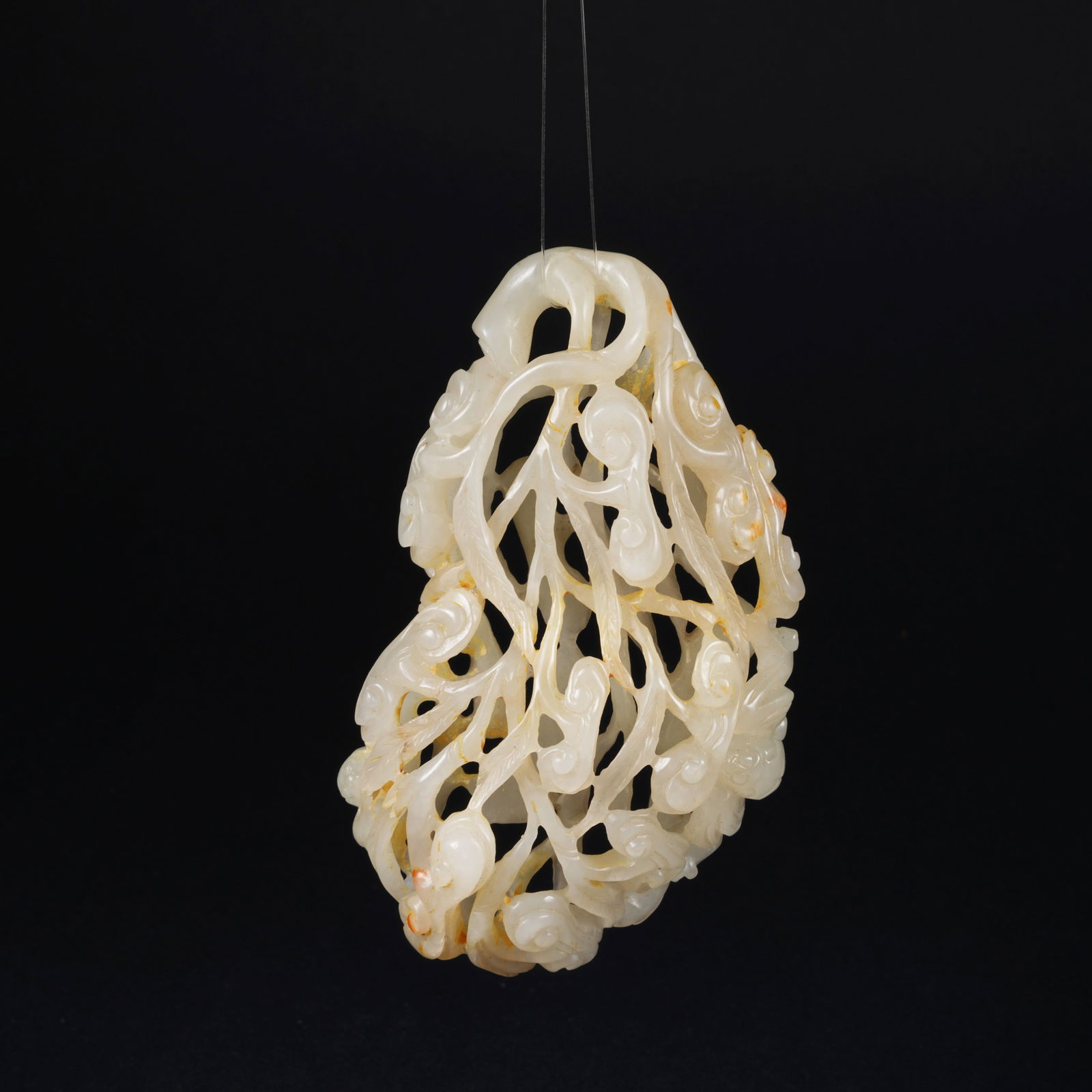 A HETIAN JADE OPENWORK PENDANT WITH LINGZHI MOTIF: Hetian jade openwork pendant with lingzhi motif