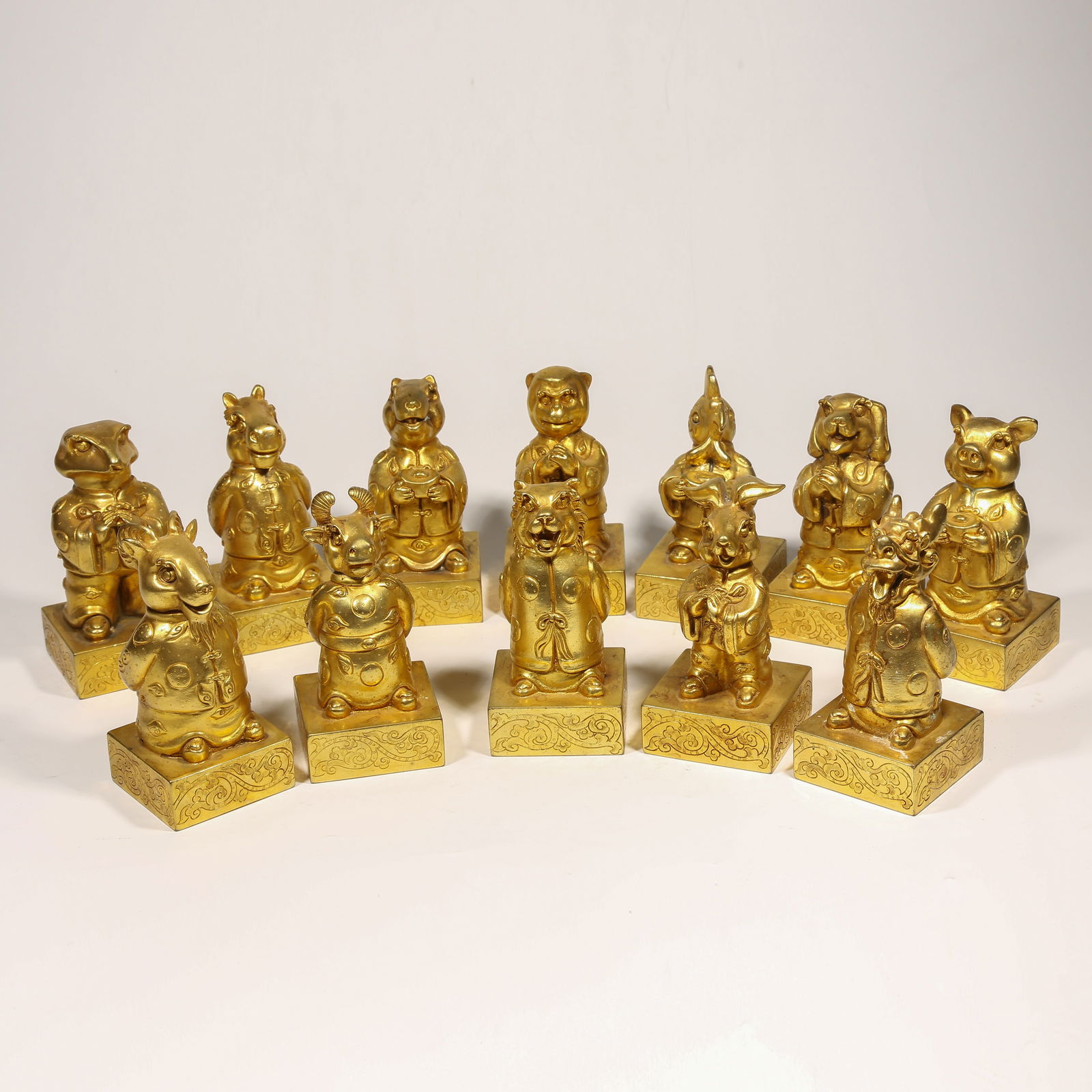 A GILDED BRONZE SEAL SET WITH TWELVE ZODIAC KNOBS: Gilded Bronze Seal Set with Twelve Zodiac Knobs