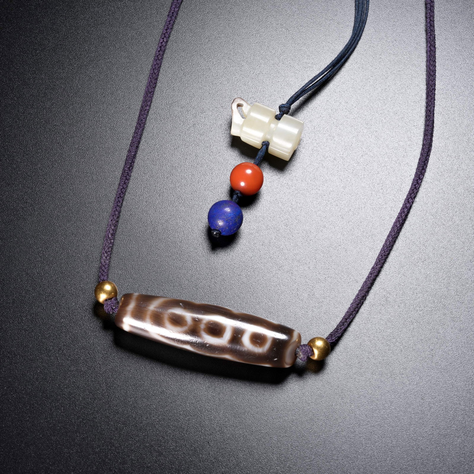 A AGATE FIVE-EYED DZI BEAD STRAND: Agate Five-Eyed Dzi Bead Strand