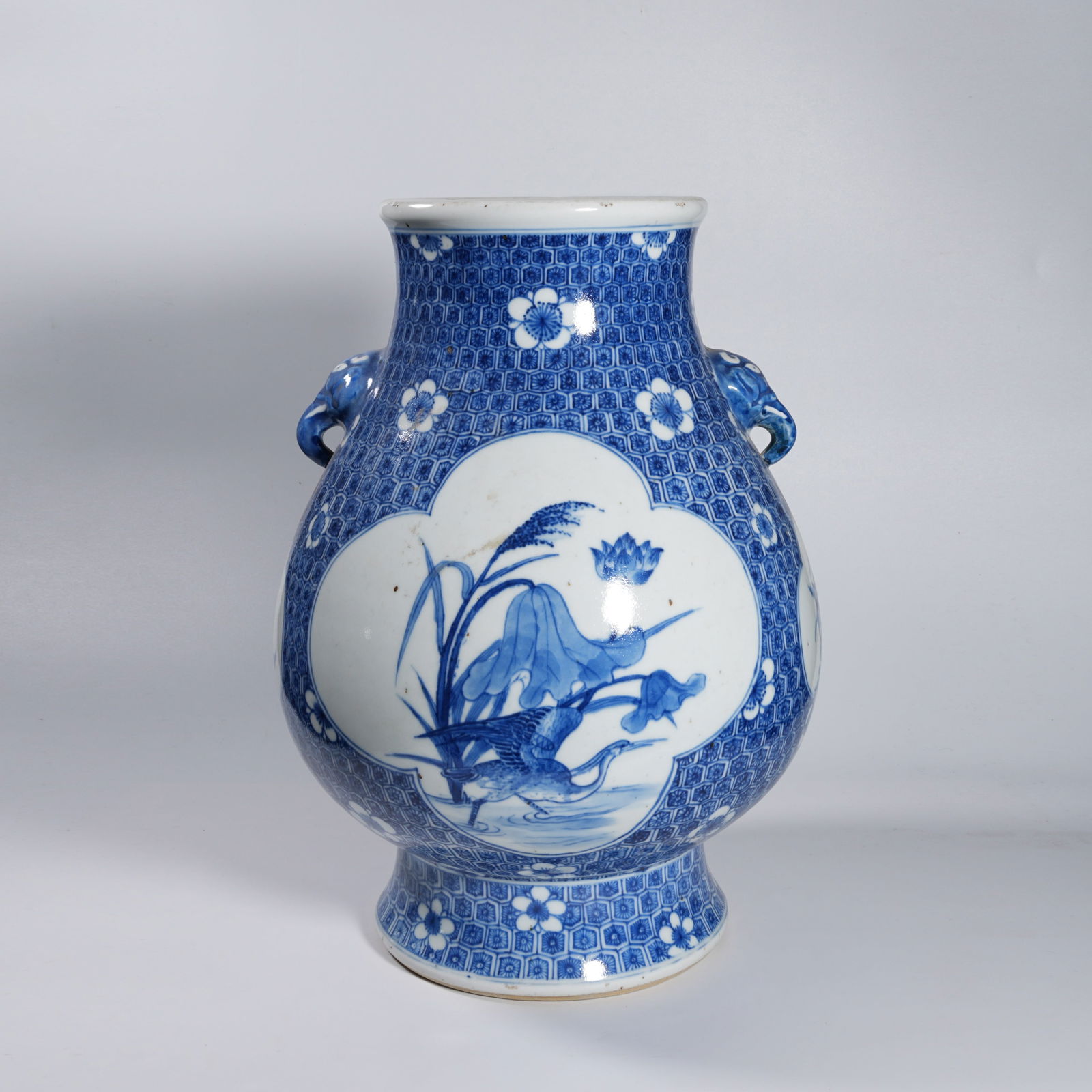 A BLUE-AND-WHITE ELEPHANT-EAR ZUN WITH BIRD-AND-FLOWER MOTIFS: Blue-and-white elephant-ear zun with bird-and-flower motifs