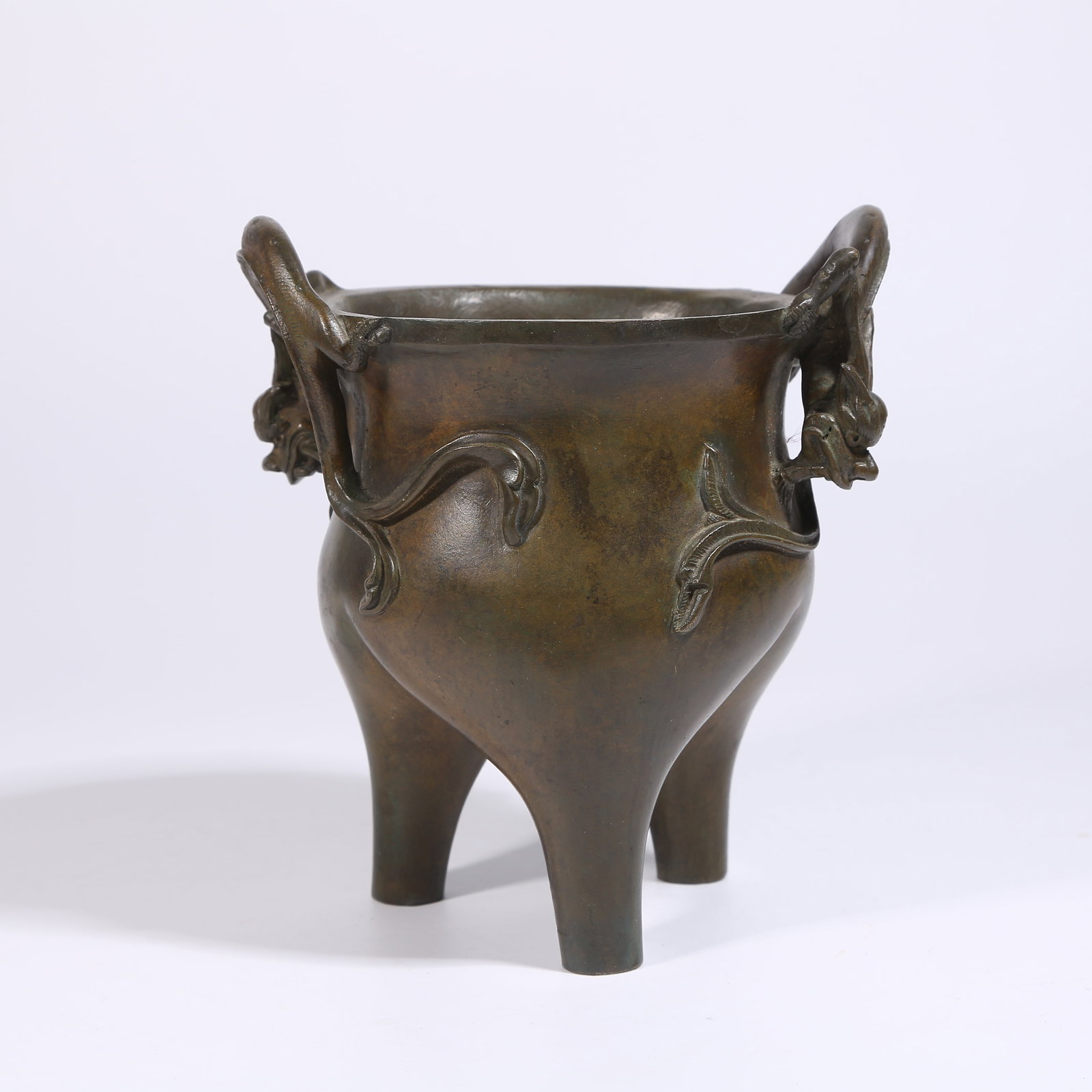 A BRONZE TRIPOD CENSER WITH DRAGON HANDLES: Bronze tripod censer with dragon handles