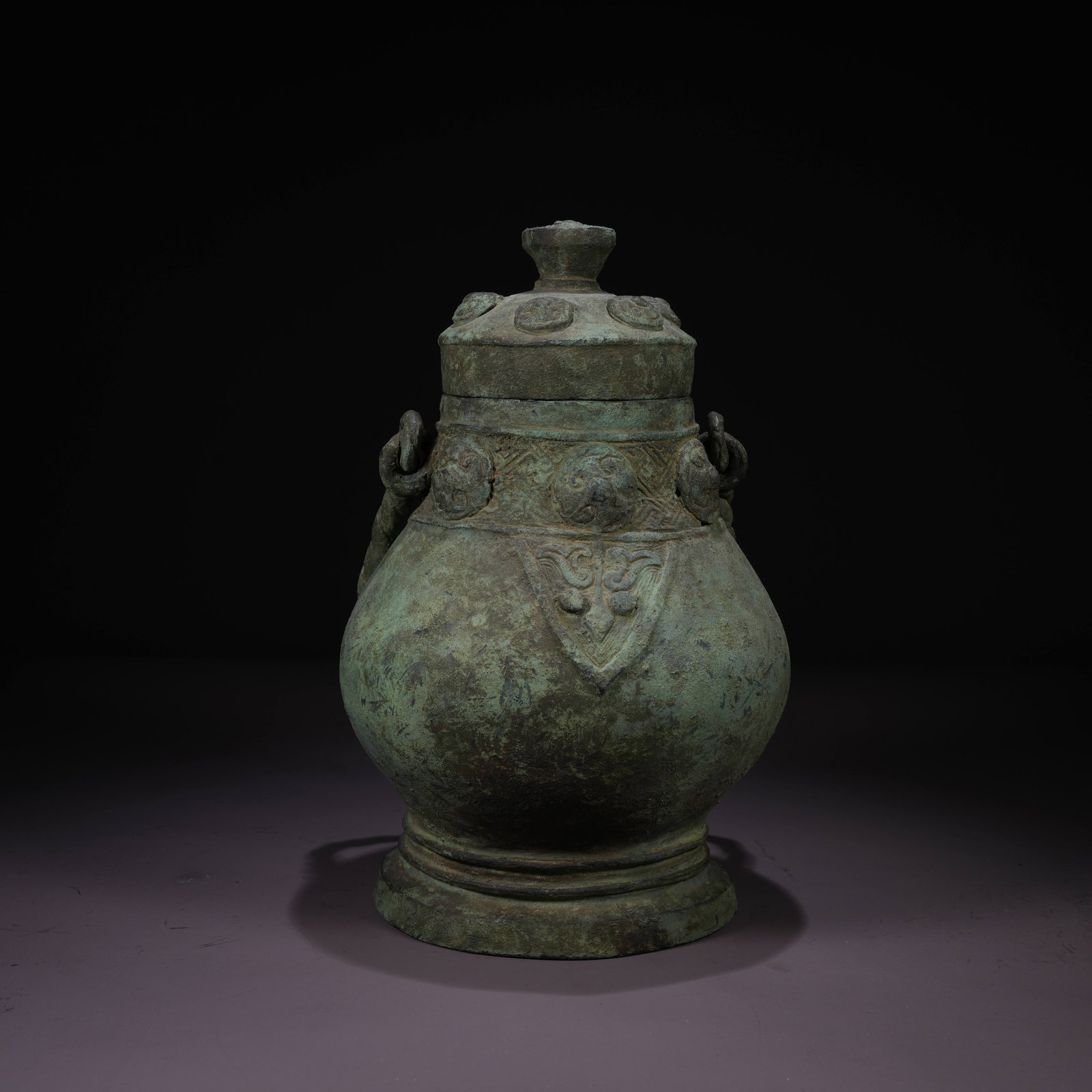 A BRONZE YOU VESSEL WITH TAOTIE MASK AND SWING HANDLE: Bronze You Vessel with Taotie Mask and Swing Handle