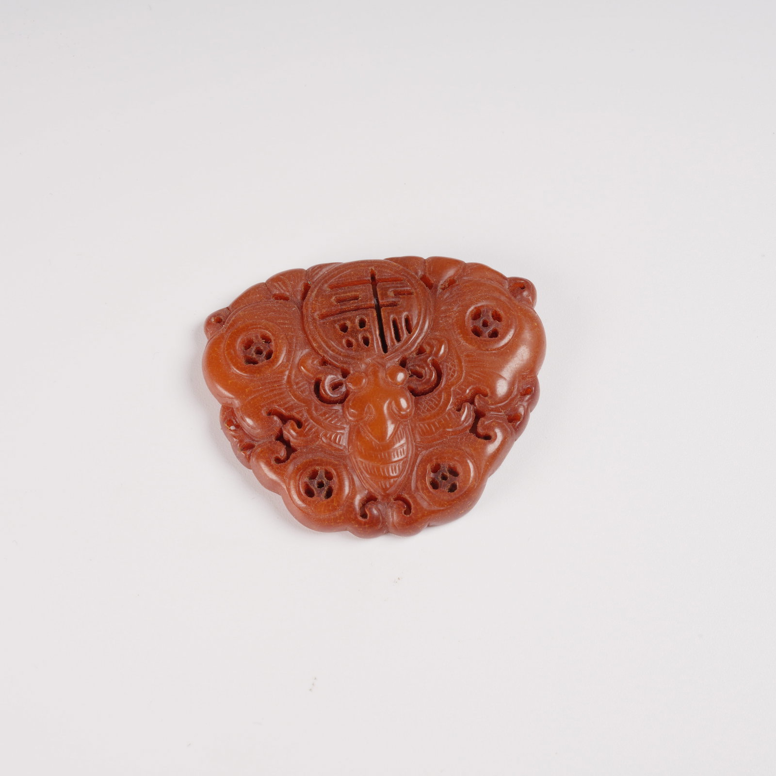 A HONEY-AMBER PENDANT WITH WEALTH-AND-FORTUNE MOTIF: Honey-amber pendant with wealth-and-fortune motif