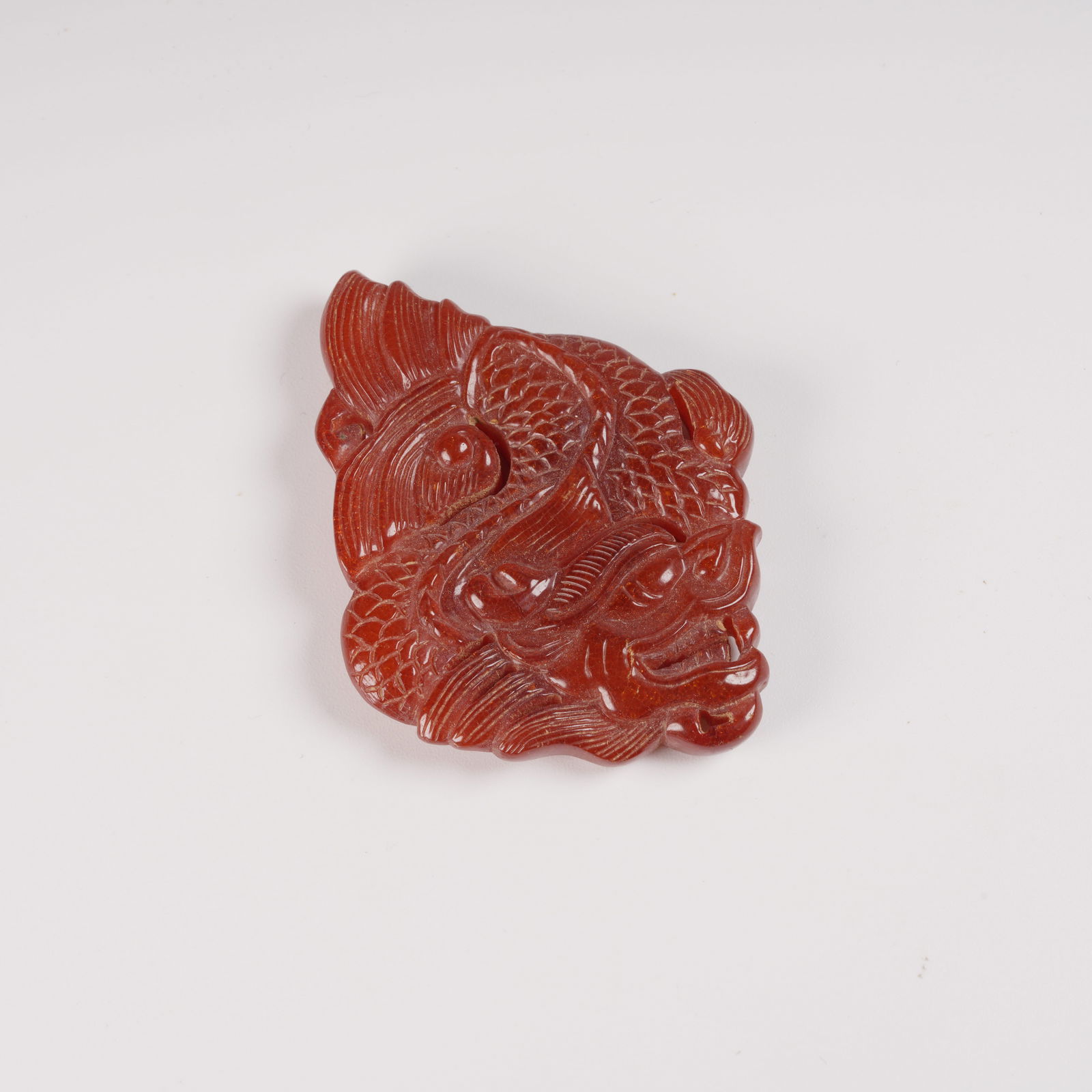 A HONEY-AMBER PENDANT WITH DRAGON MOTIF: Honey-amber pendant with dragon motif