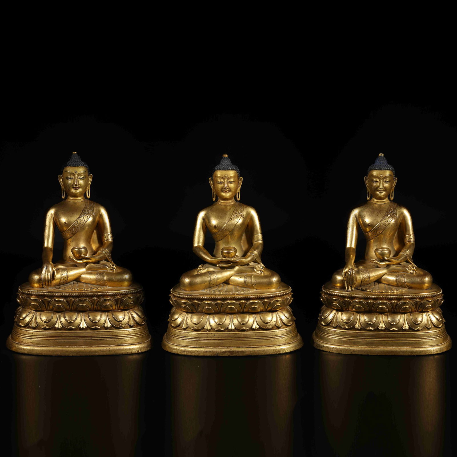 A GROUP OF THREE GILT-BRONZE BUDDHAS (THREE BUDDHAS OF THE THREE TIMES): Group of Three Gilt-Bronze Buddhas (Three Buddhas of the Three Times)