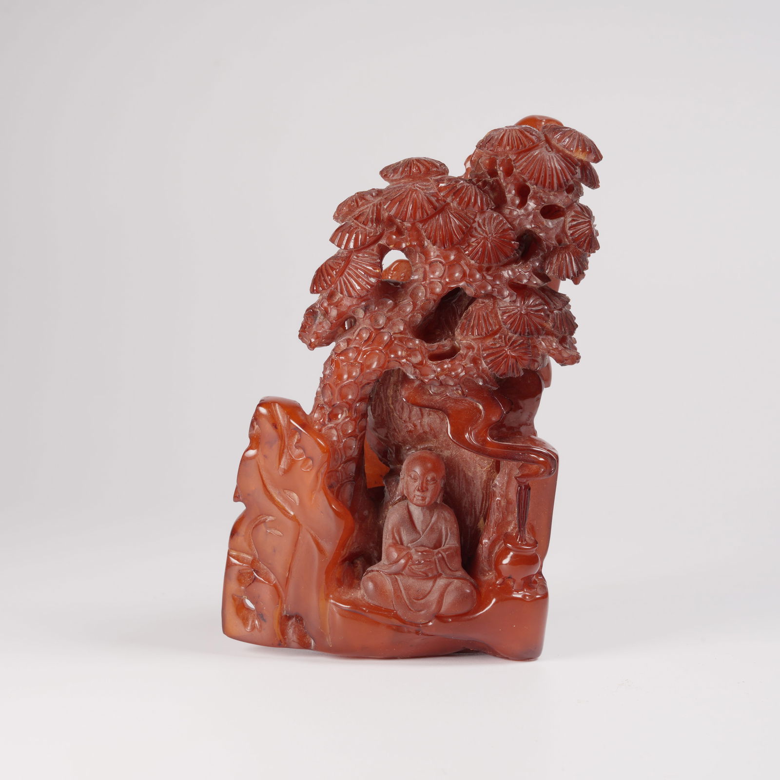 A HONEY-AMBER MOUNTAIN ORNAMENT WITH "ENLIGHTENMENT UNDER PINE" SCENE: Honey-amber mountain ornament with "Enlightenment under Pine" scene
