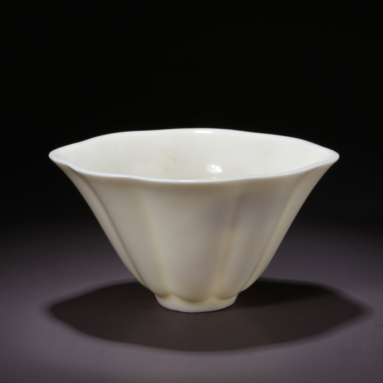 A DEHUA WHITE PORCELAIN CUP IN THE SHAPE OF A LOTUS LEAF: Dehua White Porcelain Cup in the Shape of a Lotus Leaf