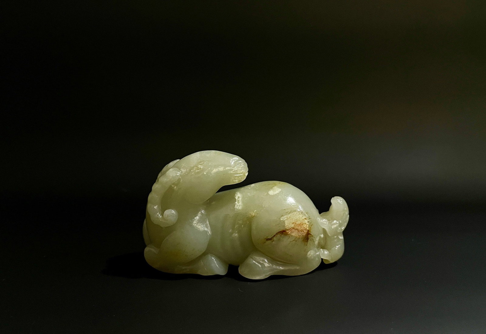 A HETIAN SEED-JADE RECLINING RAM ORNAMENT (1 of 9)