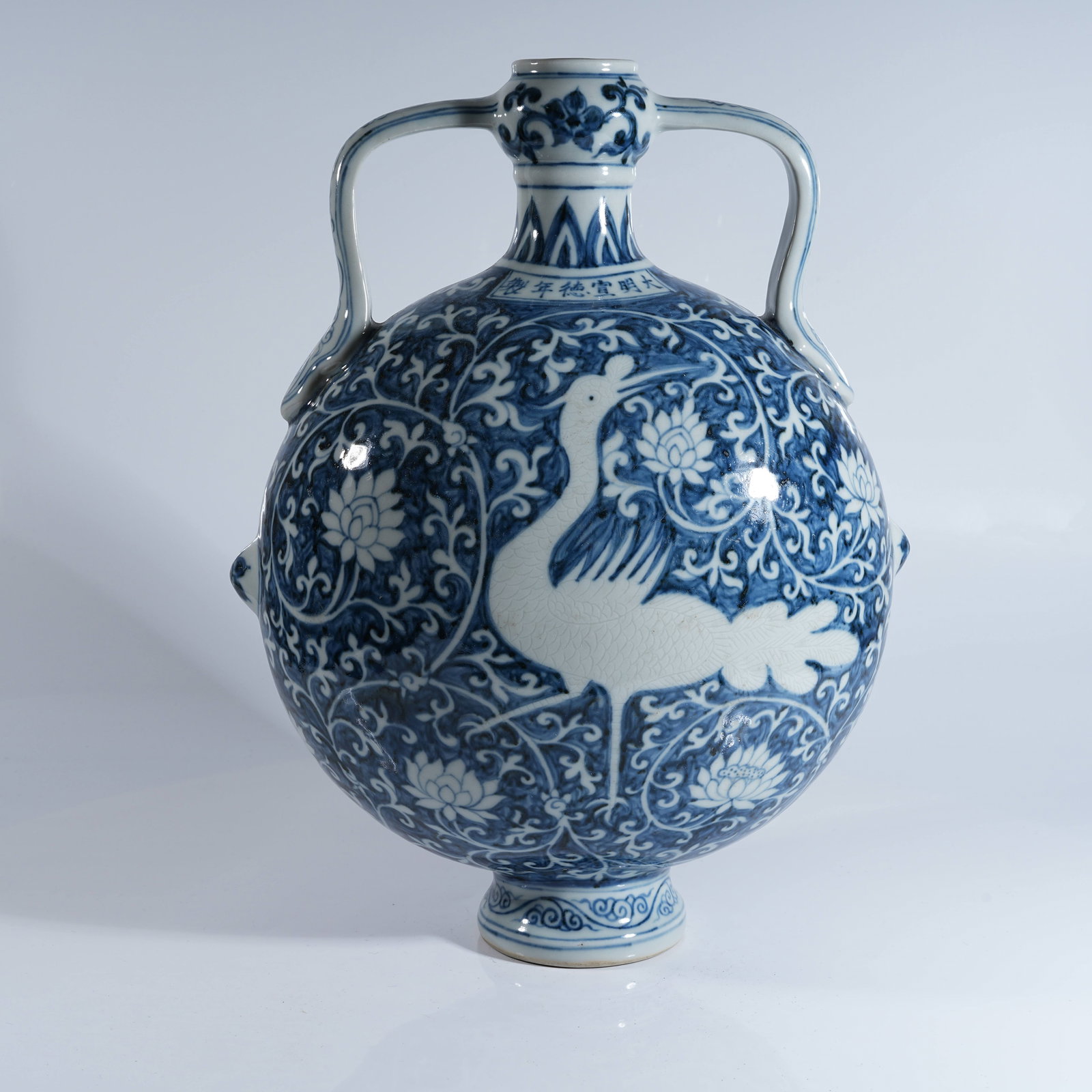 A BLUE AND WHITE MOON VASE WITH RIBBON EARS AND RESERVED PHOENIX AMIDST FLORAL PATTERNS: Blue and White Moon Vase with Ribbon Ears and Reserved Phoenix Amidst Floral Patterns