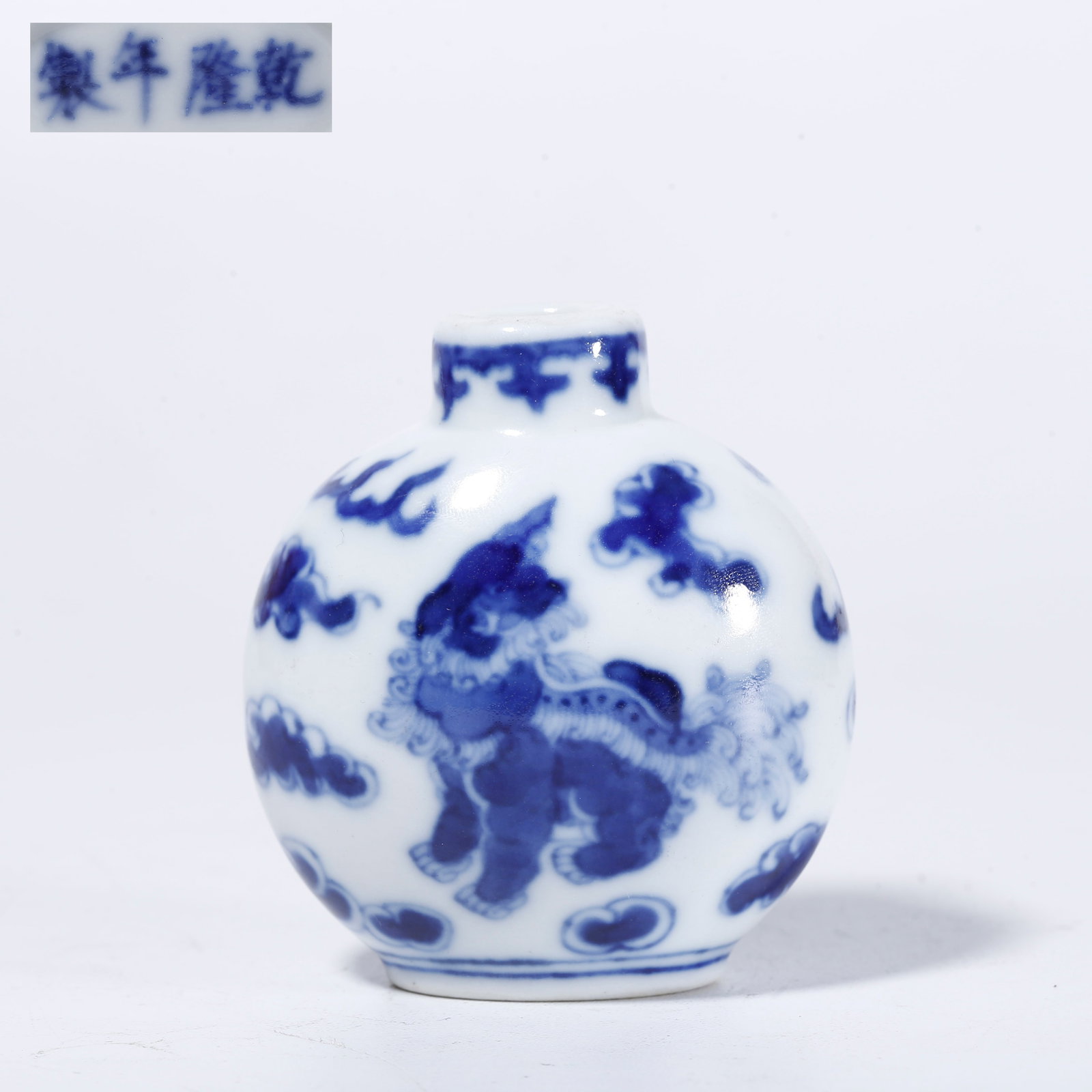 A BLUE-AND-WHITE LION PLAYING WITH A BALL PATTERN SNUFF BOTTLE: Blue-and-white lion playing with a ball pattern snuff bottle