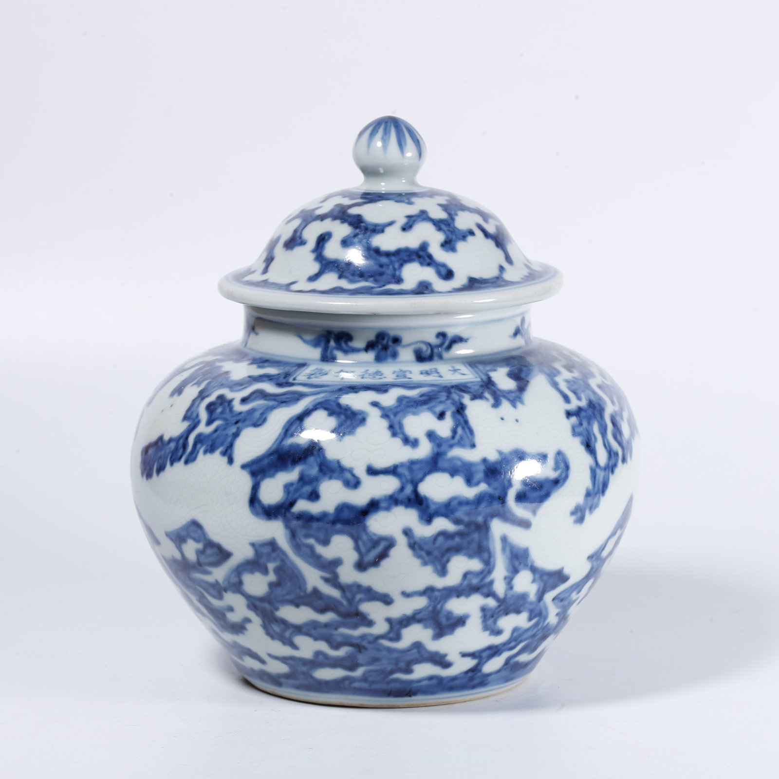 A BLUE-AND-WHITE RESERVE CLOUD-AND-DRAGON COVERED JAR: Blue-and-white reserve cloud-and-dragon covered jar