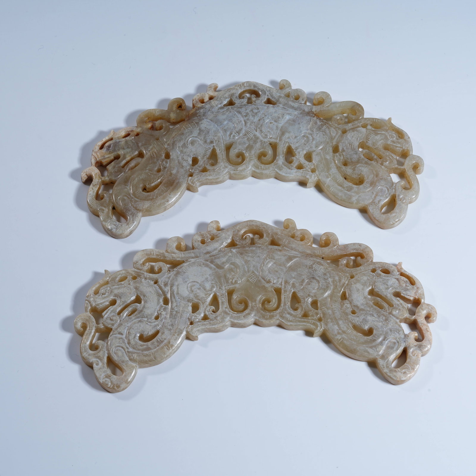A GROUP OF ANCIENT JADE DOUBLE DRAGON PENDANTS (1 of 8)
