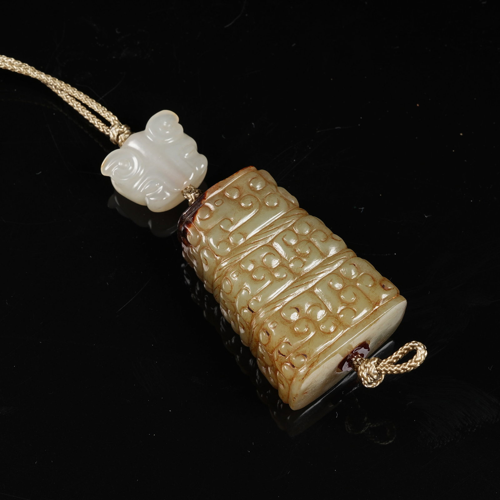 A ARCHAIC JADE CLOUD-SCROLL PATTERN CYLINDRICAL BEAD: Archaic jade cloud-scroll pattern cylindrical bead
