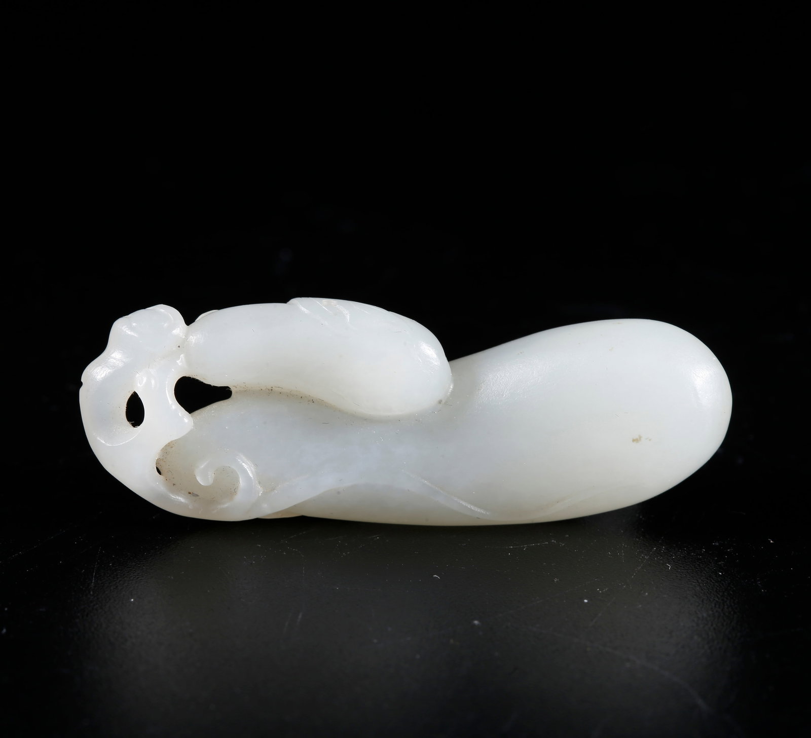A HETIAN JADE CARVED GOURD-AND-FRUIT FORM FIGURINE: Hetian jade carved gourd-and-fruit form figurine