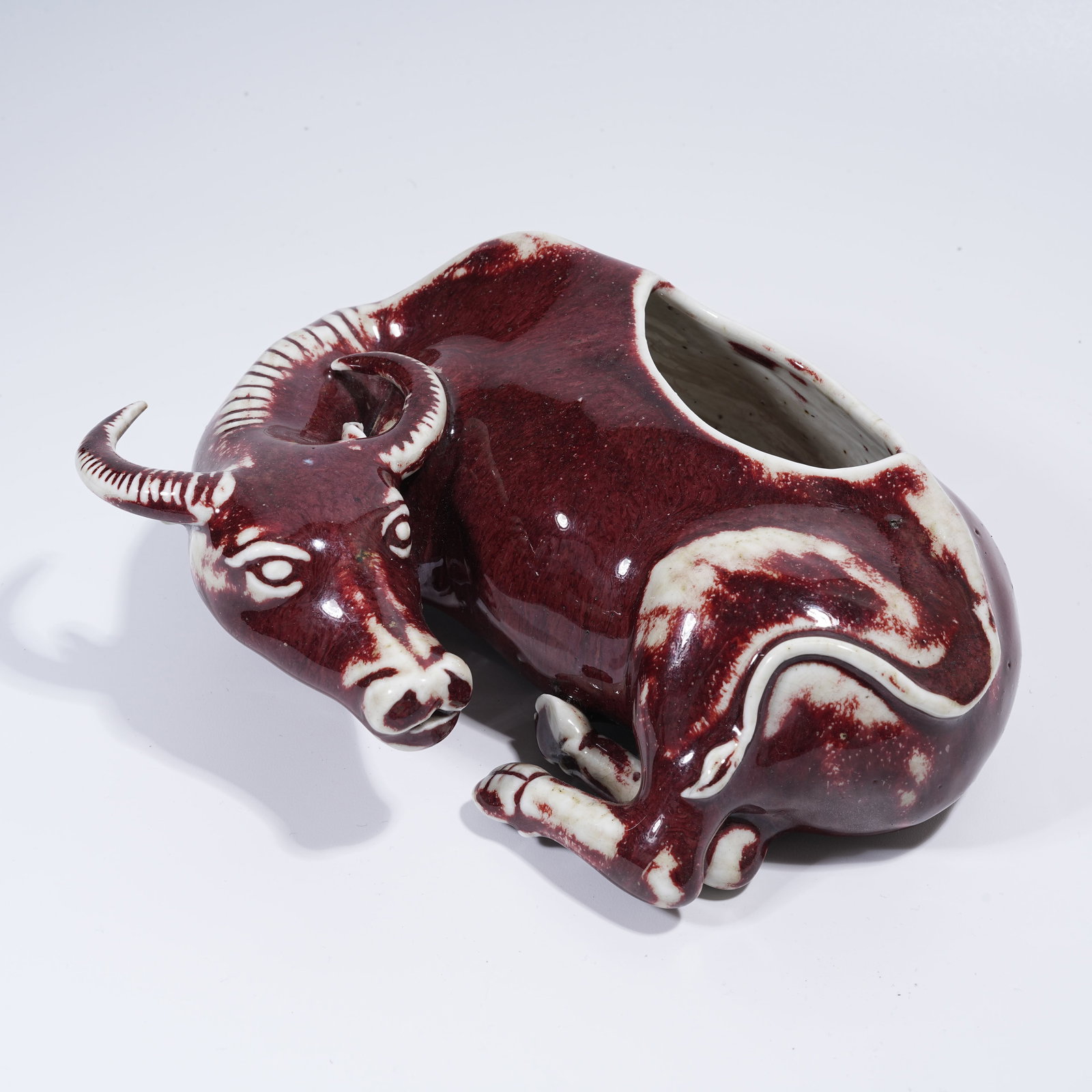 A FLAMBE GLAZE RECUMBENT OX WASHER: Flambe Glaze Recumbent Ox Washer