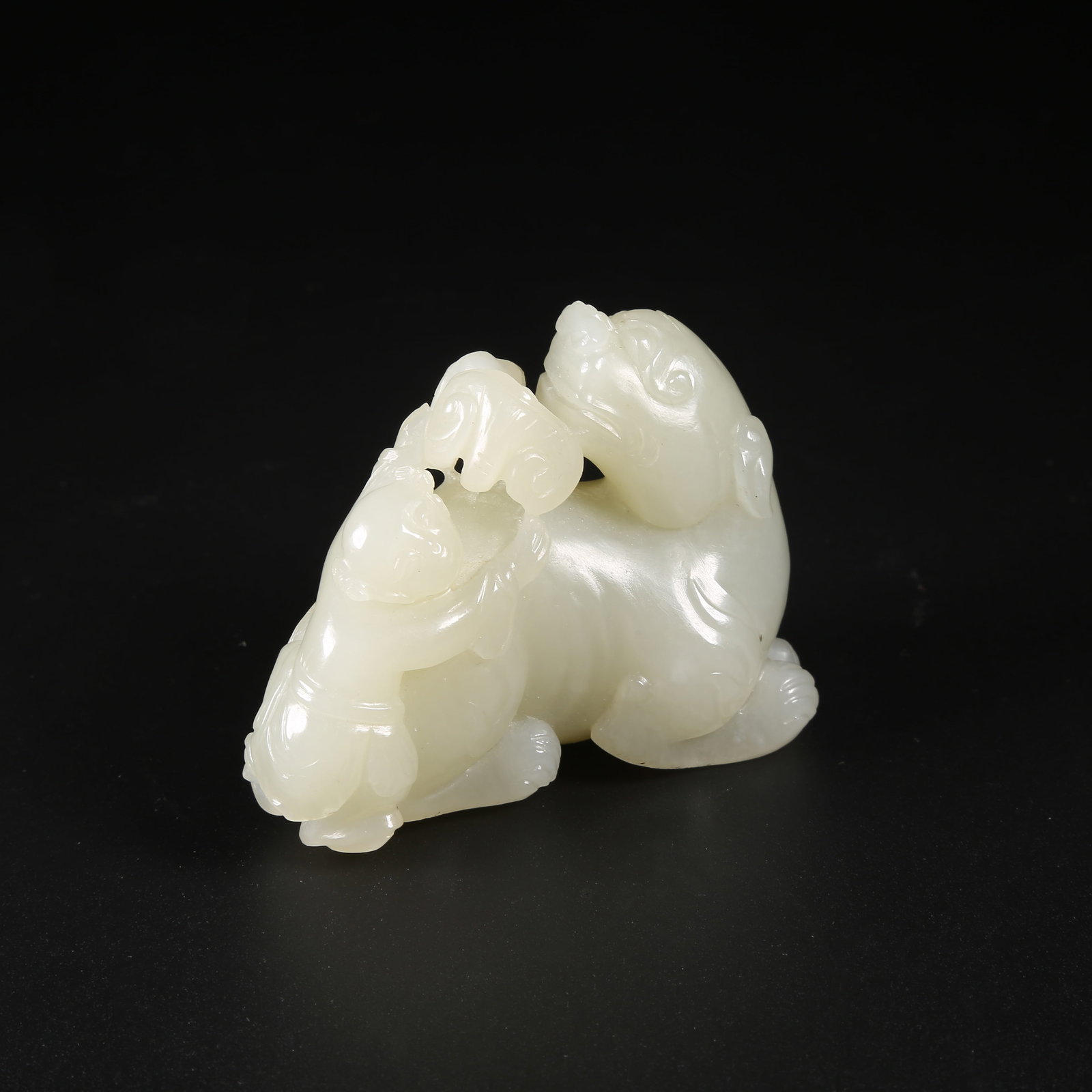 A HETIAN JADE CHILD PLAYING WITH LION ORNAMENT: Hetian Jade Child Playing with Lion Ornament