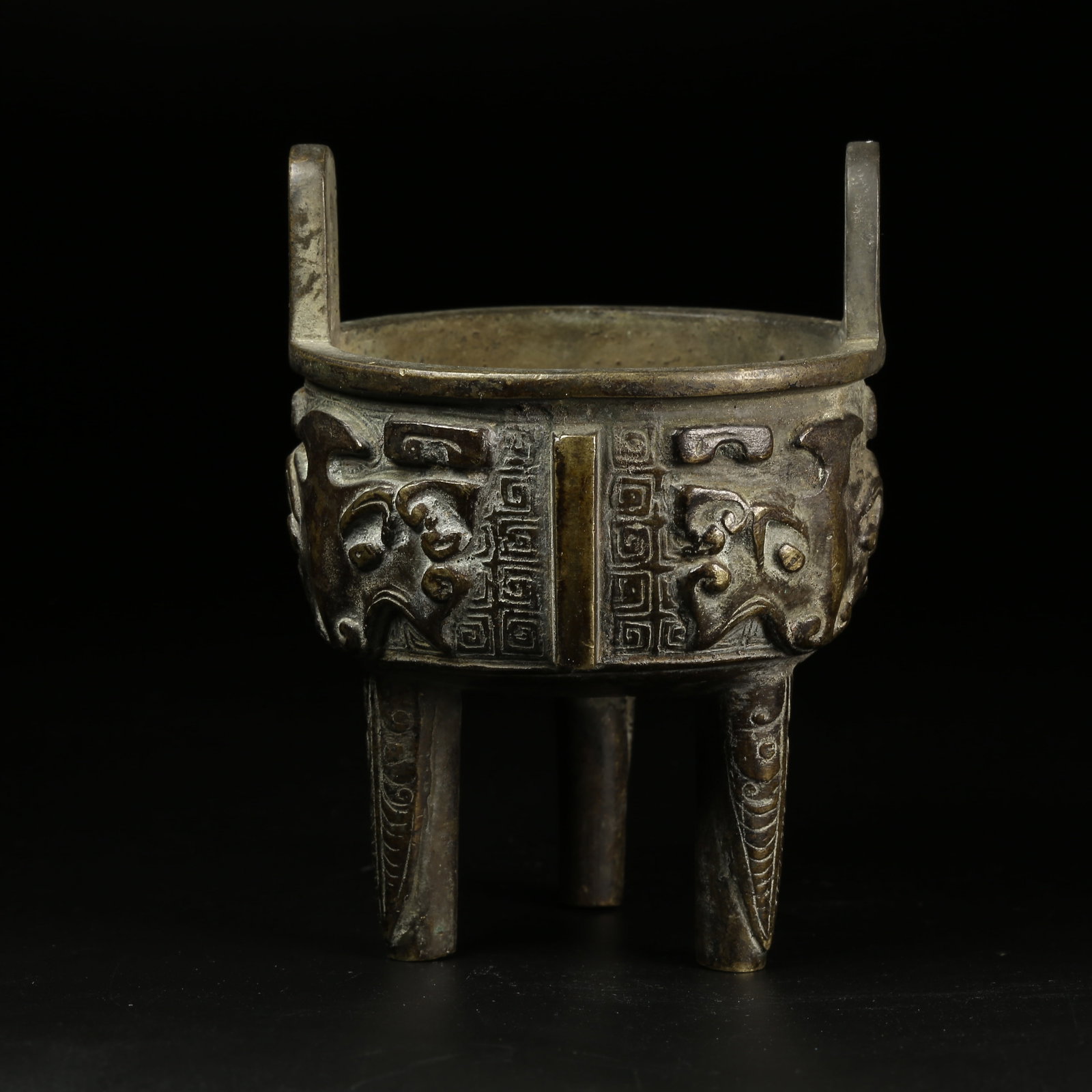 A BRONZE TRIPOD CENSER WITH TAOTIE MASK DESIGN: Bronze Tripod Censer with Taotie Mask Design