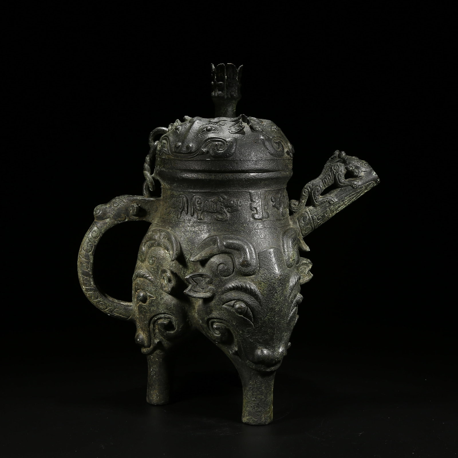 A BRONZE HE VESSEL WITH TAOTIE (BEAST FACE) PATTERN: Bronze he vessel with taotie (beast face) pattern