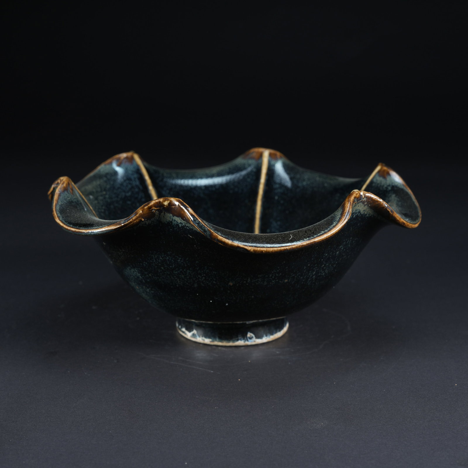 A BLACK-GLAZED SUNFLOWER-RIM RIBBED BOWL: Black-Glazed Sunflower-Rim Ribbed Bowl