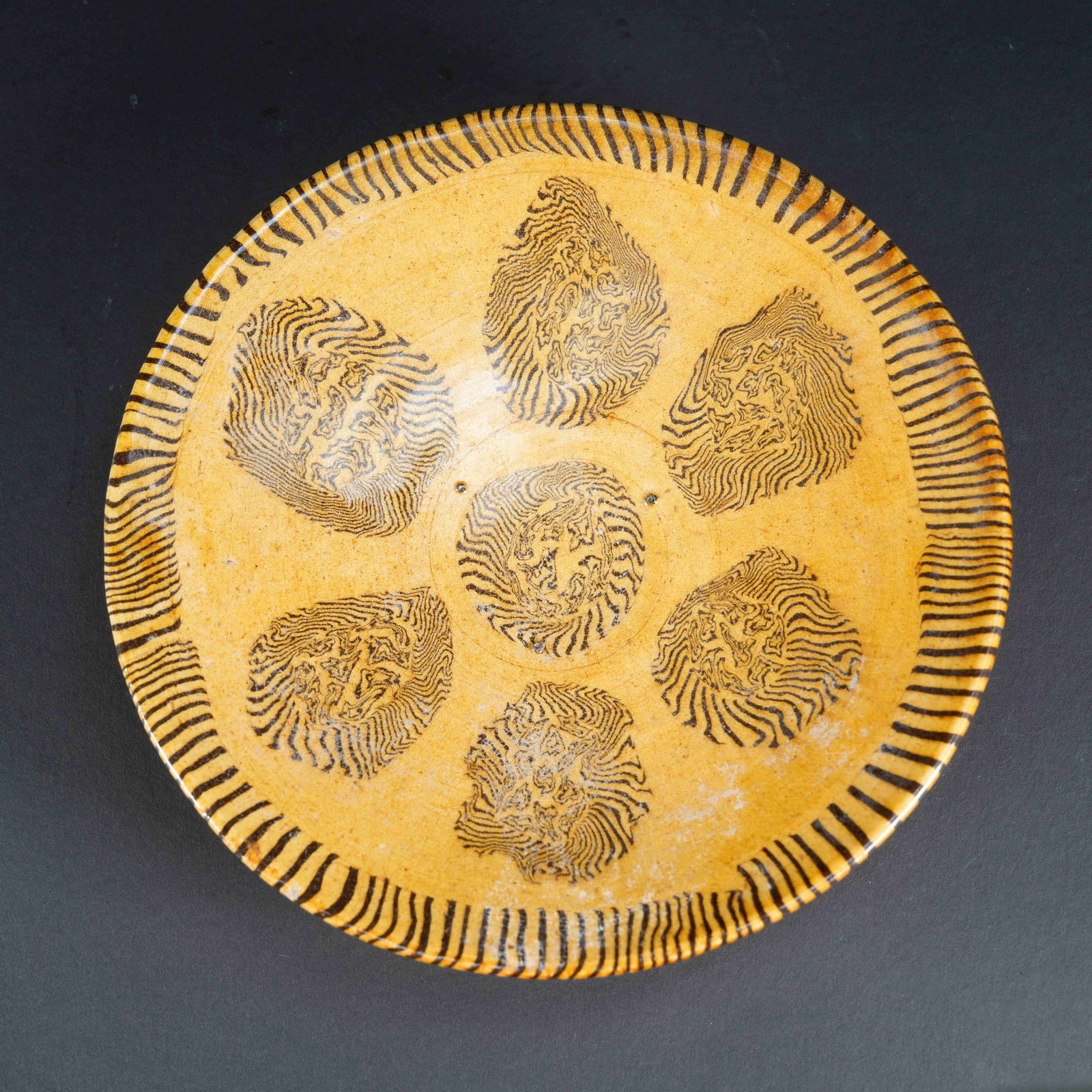 A YELLOW-GROUND MARBLED CLAY PLATE (1 of 6)