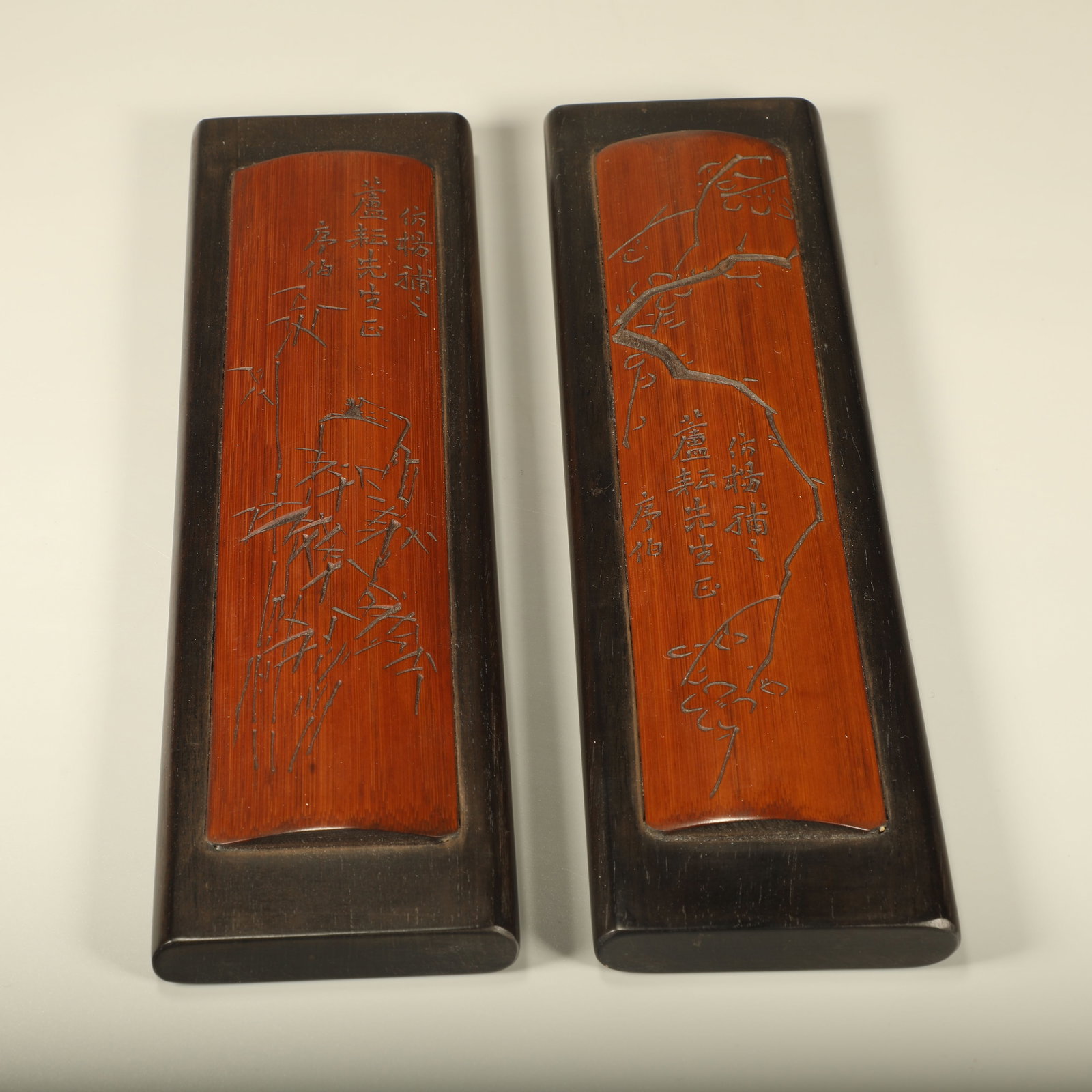 A PAIR OF RED SANDALWOOD PAPERWEIGHTS OVERLAID WITH BAMBOO AND CARVED PLUM, BAMBOO AND POEM: Pair of Red Sandalwood Paperweights Overlaid with Bamboo and Carved Plum, Bamboo and Poem Inscriptions
