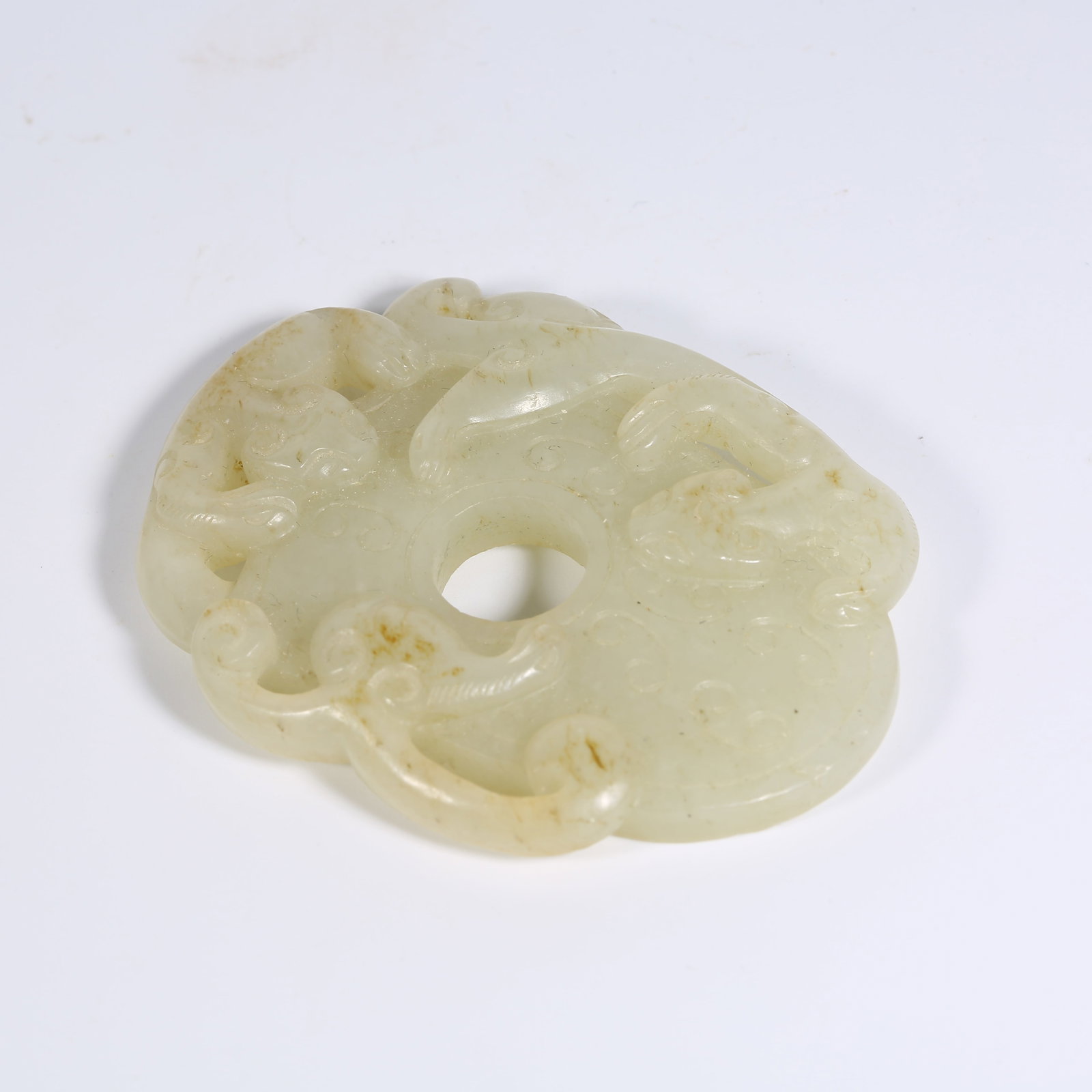 A HETIAN JADE CHICKEN-HEART PENDANT WITH CHI-DRAGON MOTIF: Hetian Jade Chicken-Heart Pendant with Chi-Dragon Motif