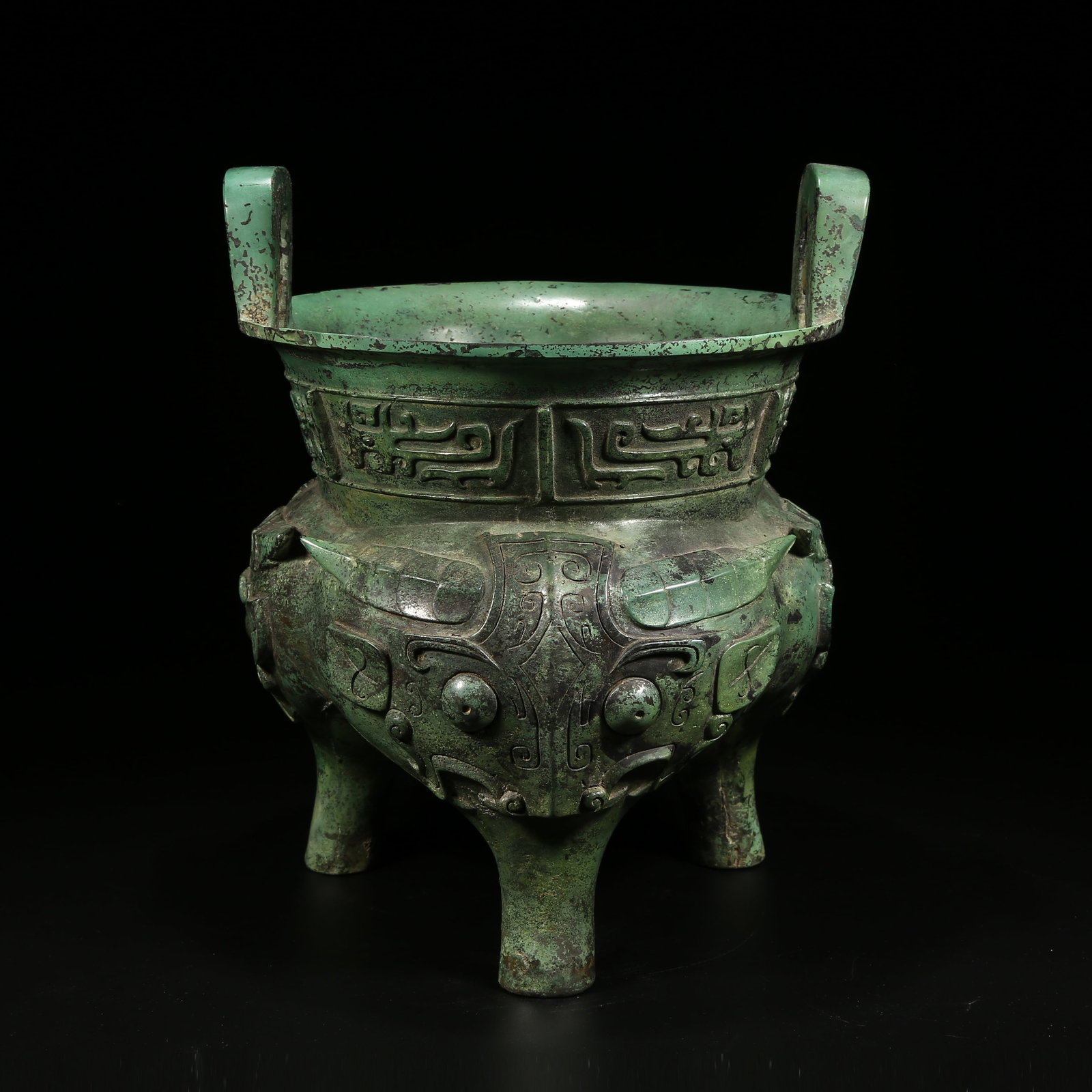 A BRONZE LI VESSEL WITH TAOTIE (BEAST FACE) PATTERN: Bronze li vessel with taotie (beast face) pattern