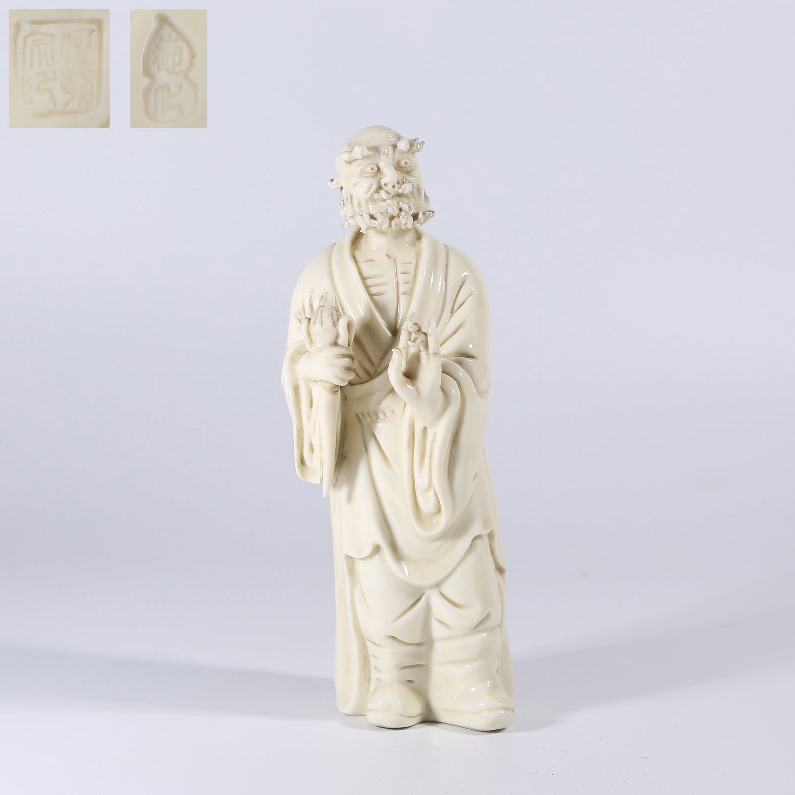 A WHITE PORCELAIN DARUMA STATUE (1 of 8)
