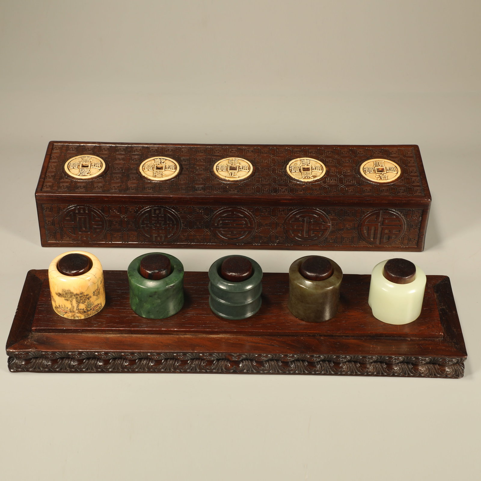 A SET OF HUANGHUALI THUMB RINGS CARVED WITH FIVE EMPERORS COINS: Set of Huanghuali Thumb Rings Carved with Five Emperors Coins