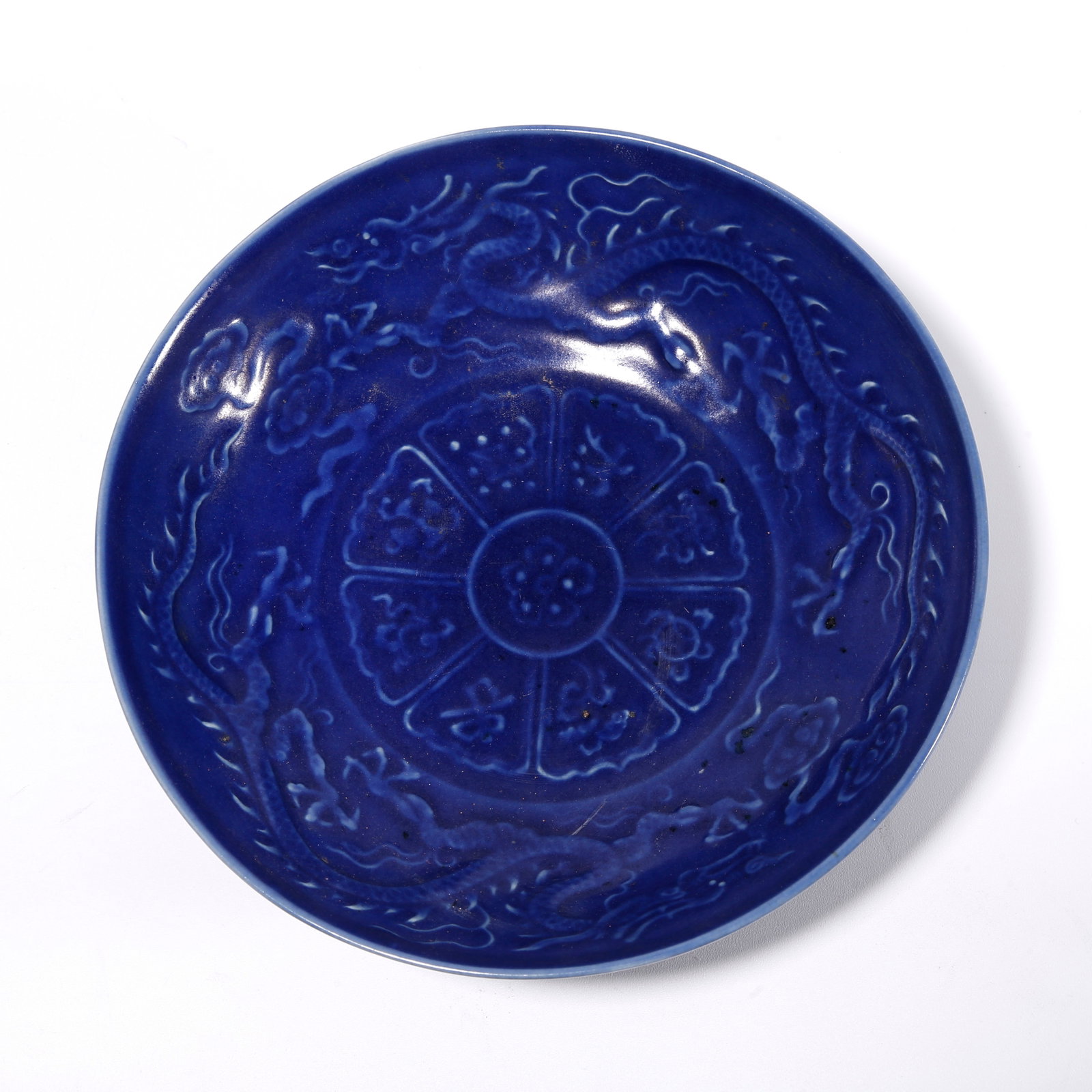 A BLUE GLAZED PLATE WITH CLOUD AND DRAGON PATTERN: Blue Glazed Plate with Cloud and Dragon Pattern