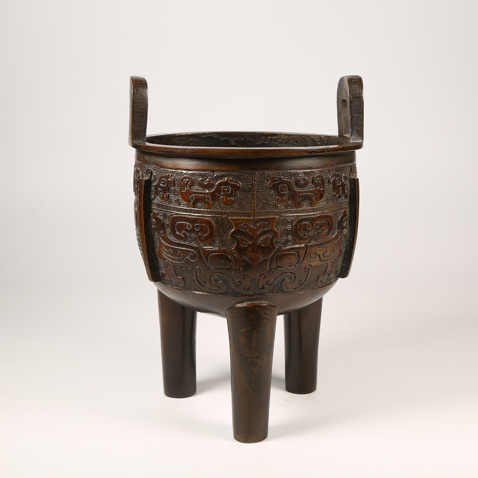 A BRONZE DING WITH ANIMAL-FACE MOTIFS AND UPRIGHT FINIALS, THREE LEGS: Bronze Ding with Animal-Face Motifs and Upright Finials, Three Legs