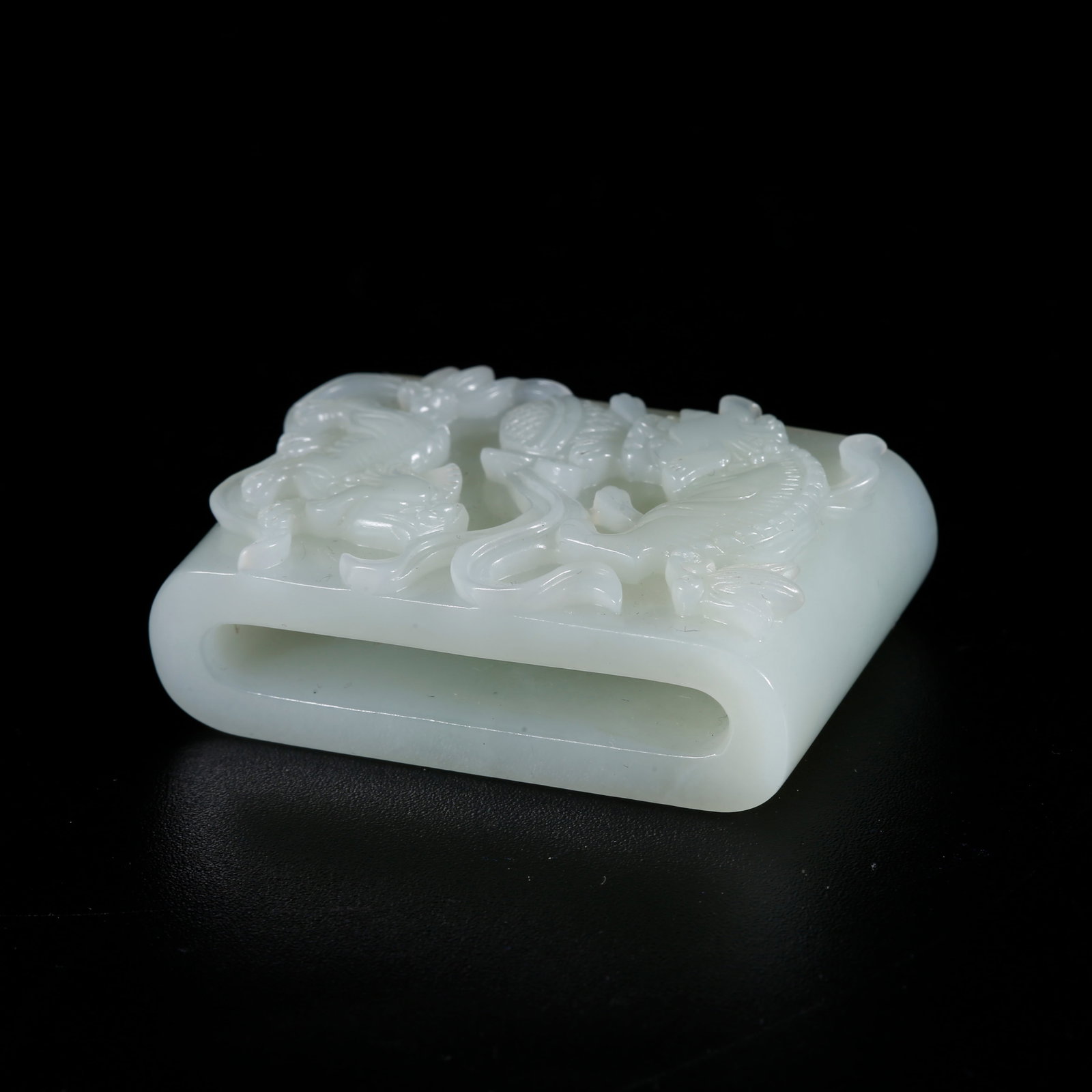 A HOTAN JADE CARVED LION PLAYING WITH EMBROIDERED BALL PENDANT: Hotan Jade Carved Lion Playing with Embroidered Ball Pendant