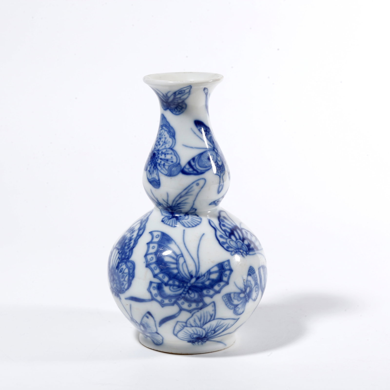 A BLUE AND WHITE GOURD VASE WITH HUNDRED BUTTERFLY PATTERN: Blue and White Gourd Vase with Hundred Butterfly Pattern