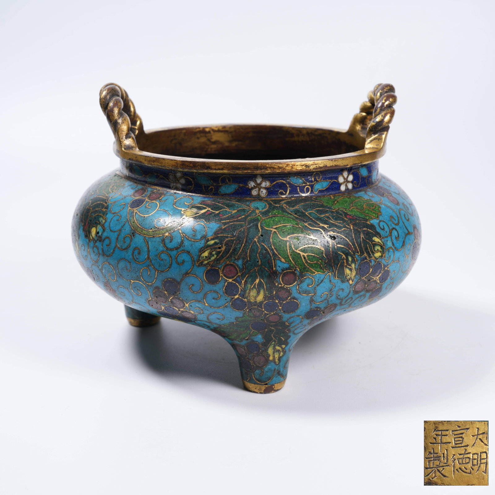 A CLOISONNÉ THREE-LEGGED CENSER WITH TWISTED EARS AND AUSPICIOUS FRUIT PATTERN: Cloisonné Three-legged Censer with Twisted Ears and Auspicious Fruit Pattern